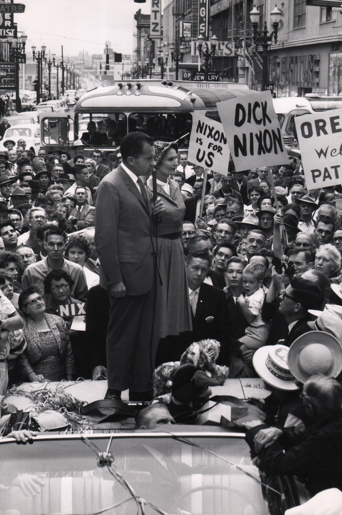 Ed Clark, Nixon campaigning in the 1960 presidential election, ​1960. Subject stands on the back of a car speaking into a microphone surrounded by a large crowd holding signs such as &quot;Nixon is for us&quot; and &quot;Dick Nixon&quot;