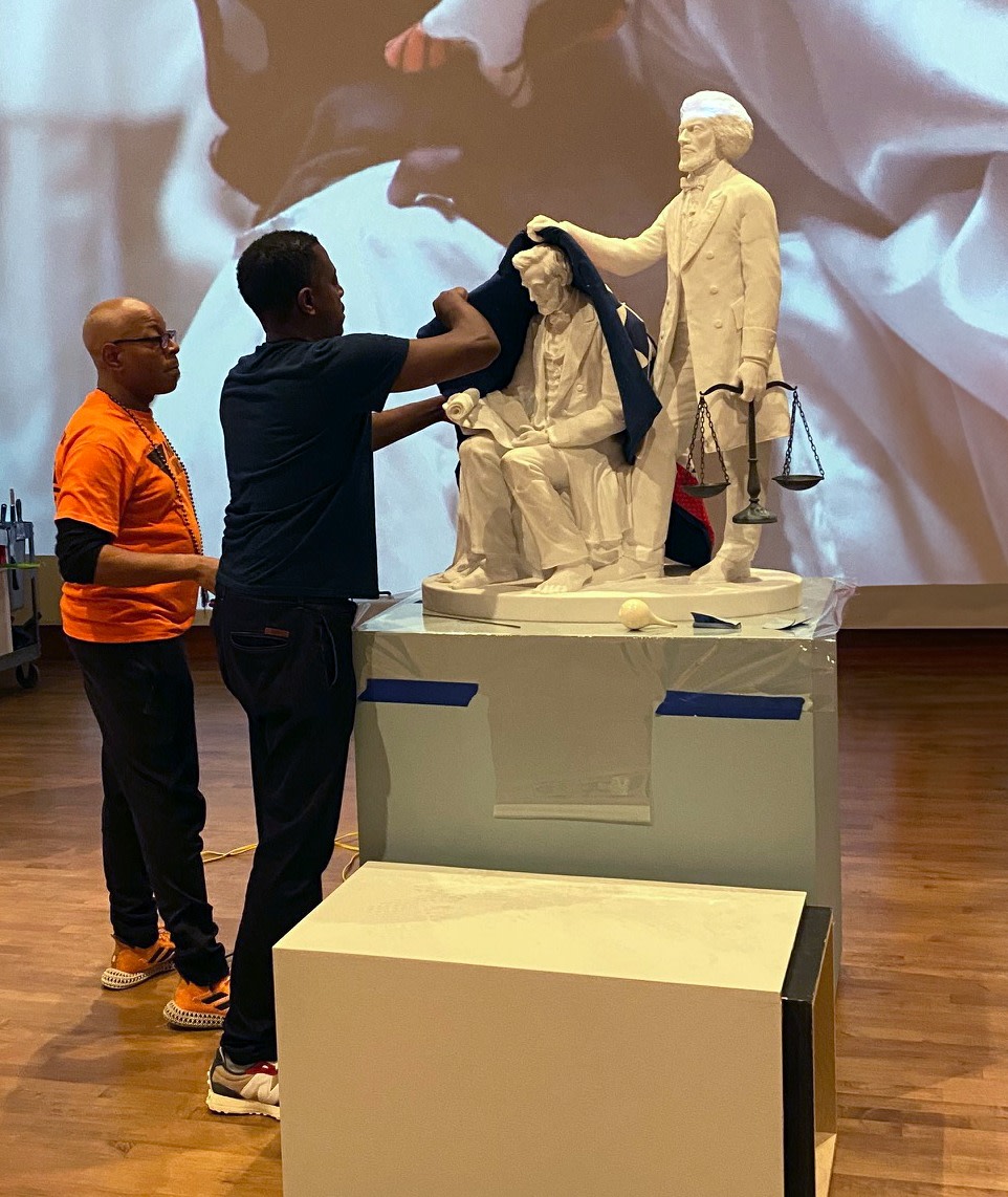 Artist Sanford Biggers and Mark Hines of MASK CONSORTIUM adding the antique red, white and blue quilt to the stone sculpture.