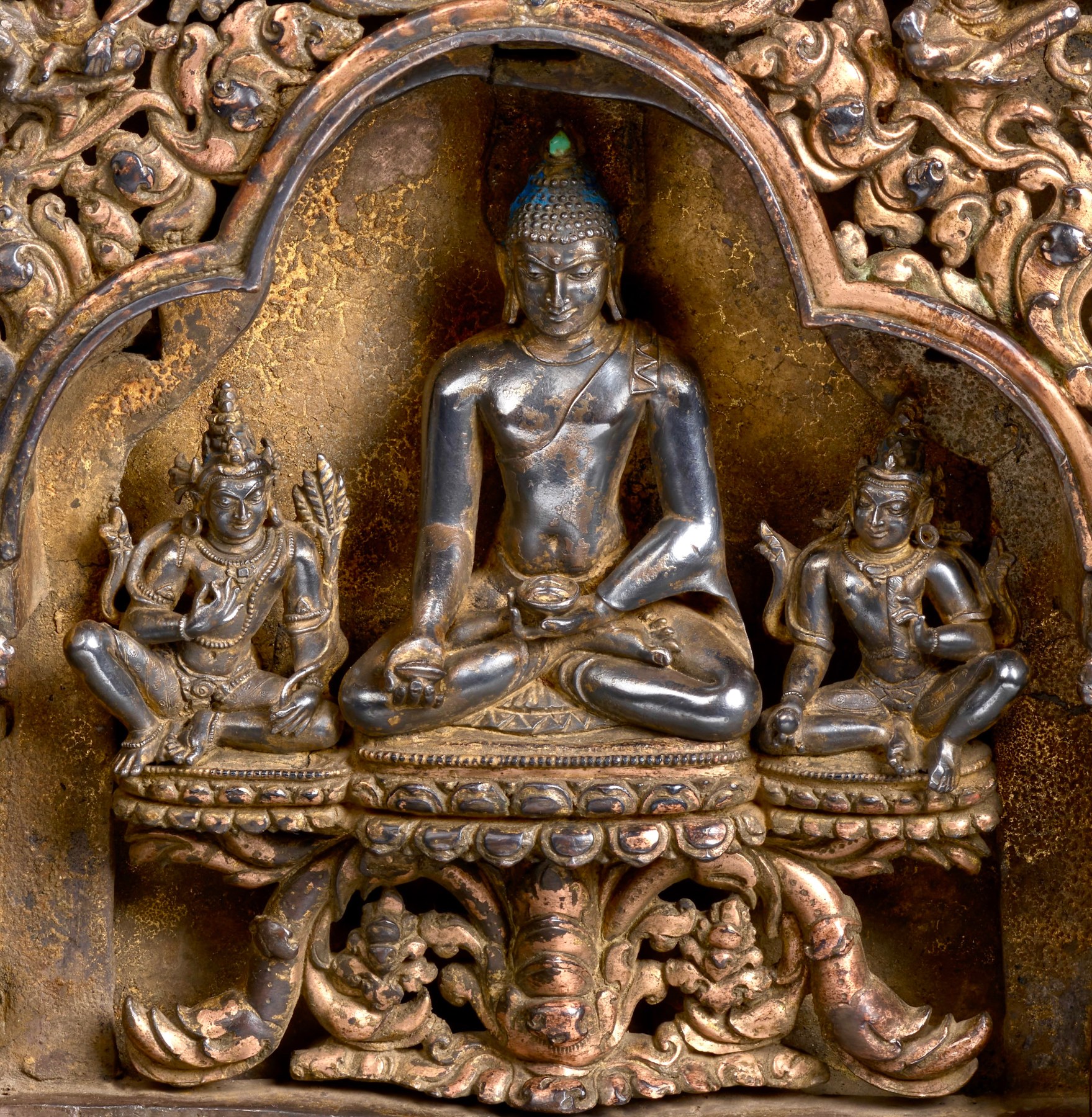 Fourth detail of This plinth from an important eastern Indian stupa is assembled from four separately-cast gilt-copper arches (torana) with crouching elephants, rampant leogryphs, and jewel-topped pillars supporting trilobate spans, makara at either end of the crossbars, bodhisattvas and celestial figures above, and with kirtimukha at the apex.  