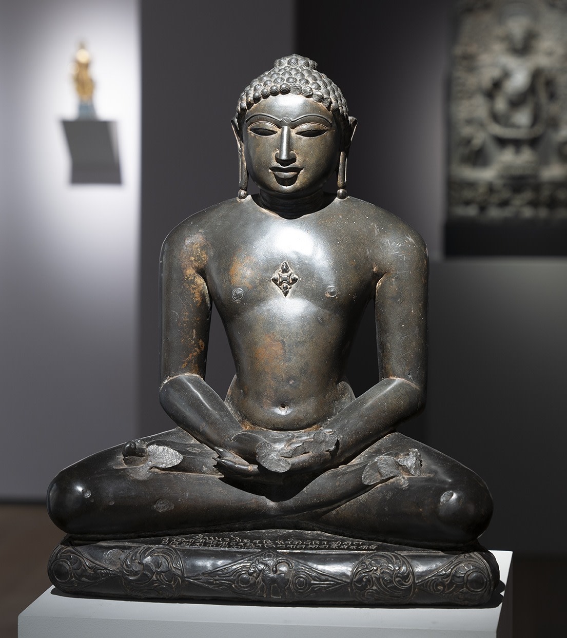 This elegant and highly-polished black stone figure of a jina is a superlative example of 11th-century Jain sculpture