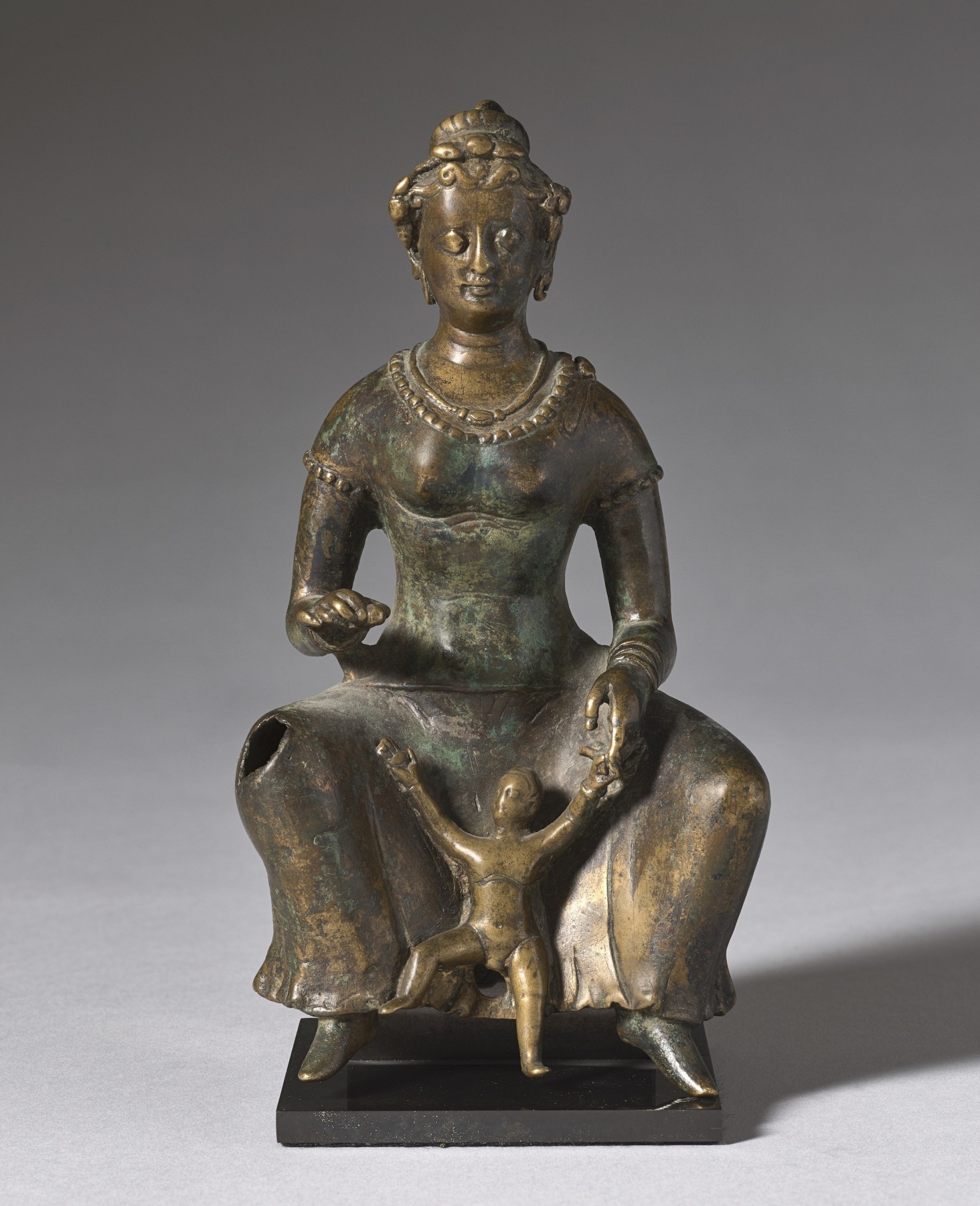 Larger version of the Same image of a Small bronze sculpture of a seated mother with her child playing between her legs