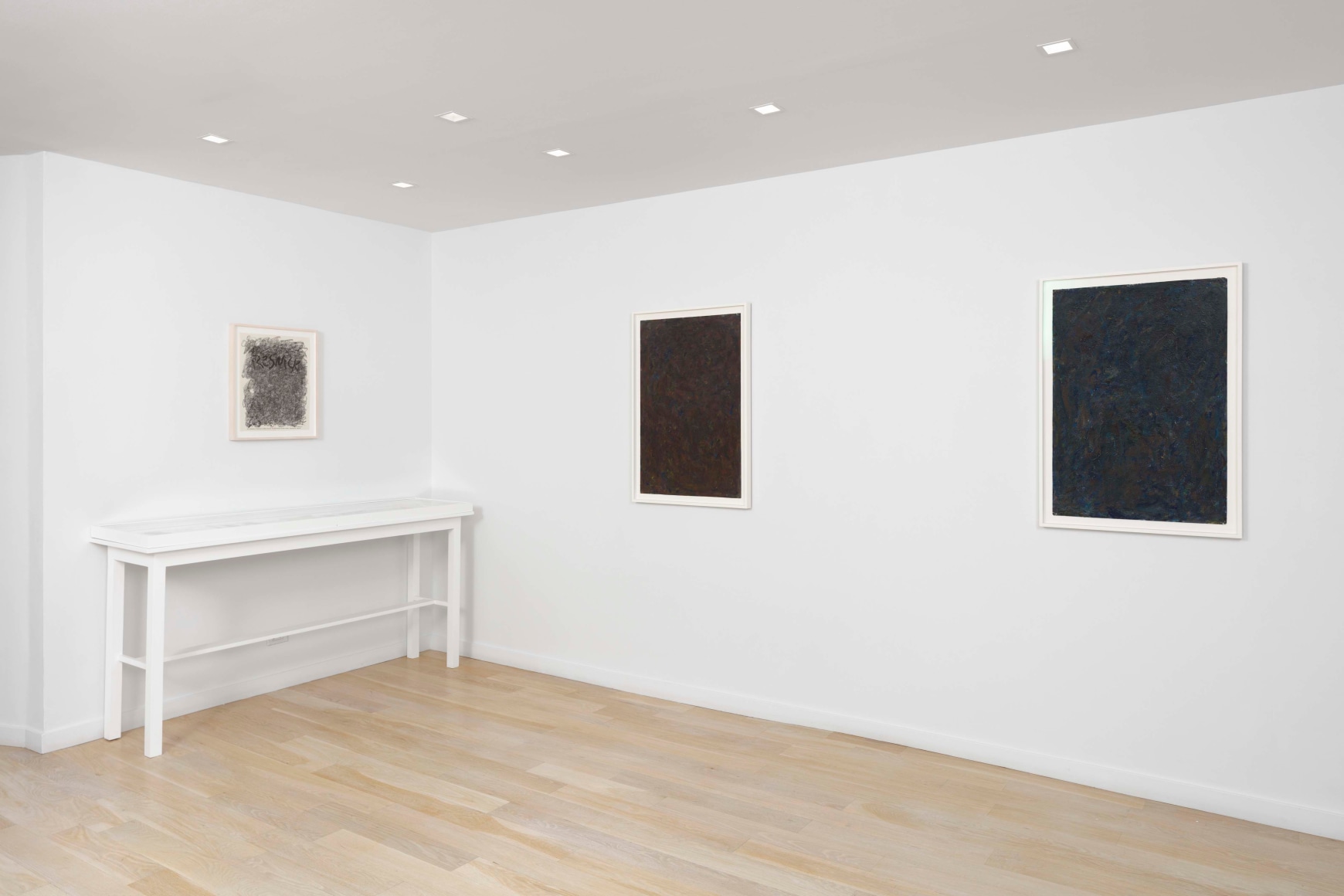 installation view of paintings in a white room