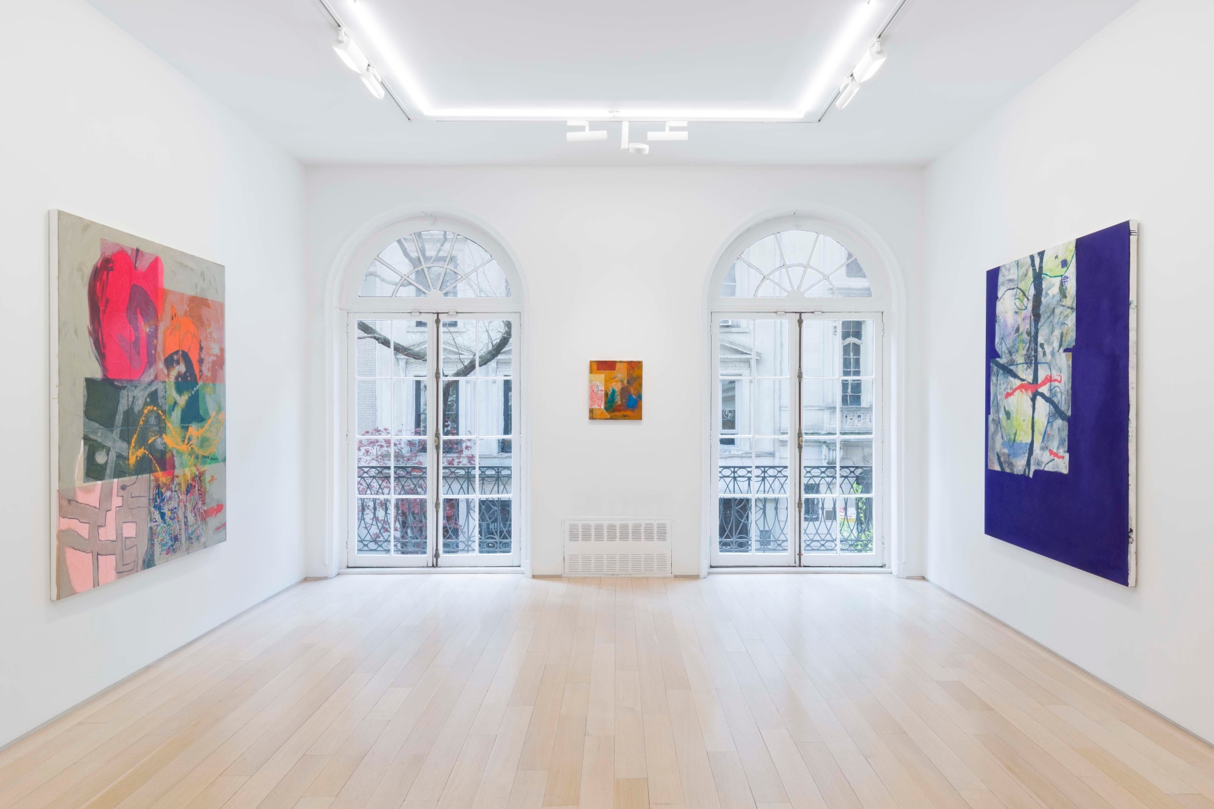 installation view of paintings in a white room
