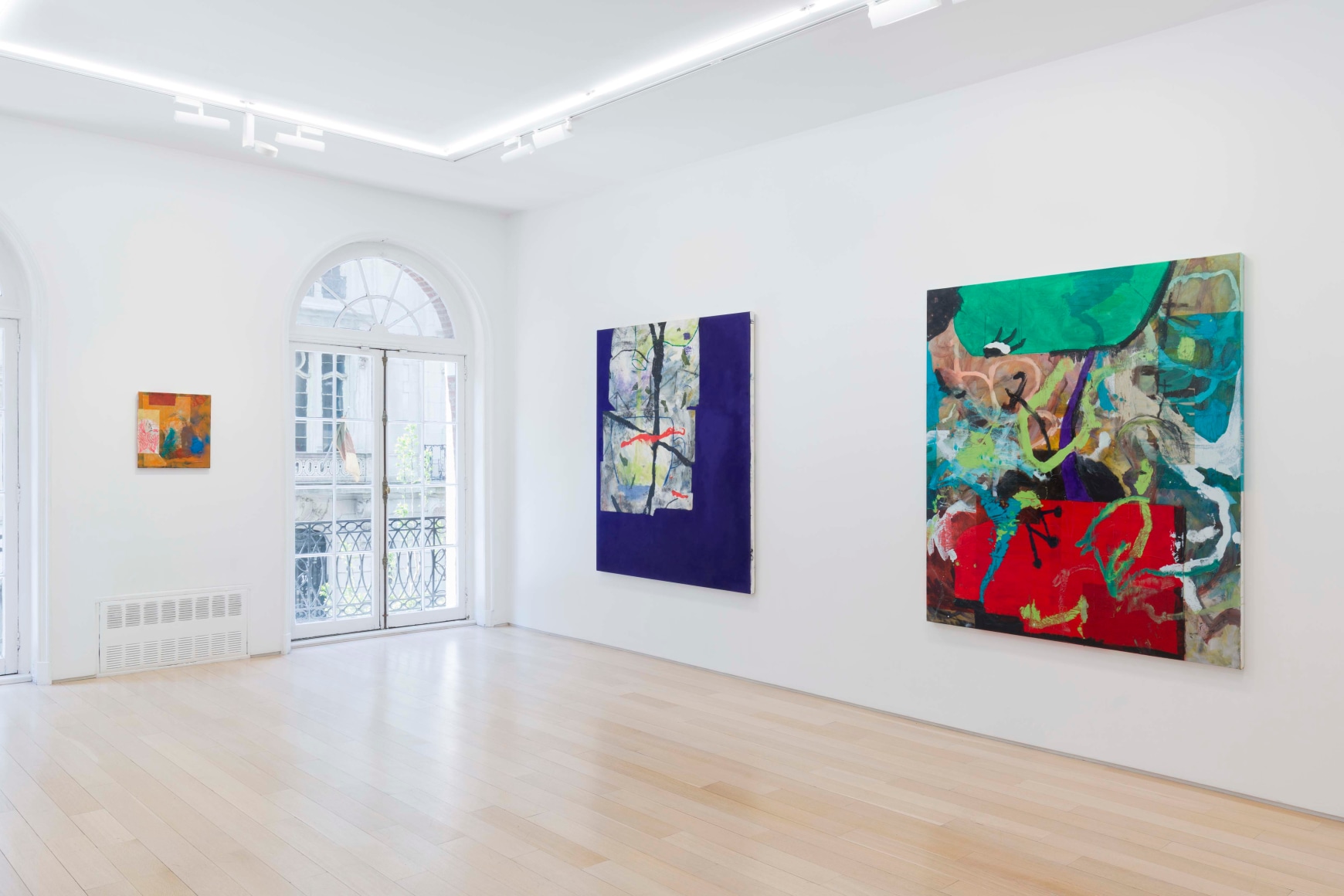installation view of paintings in a white room