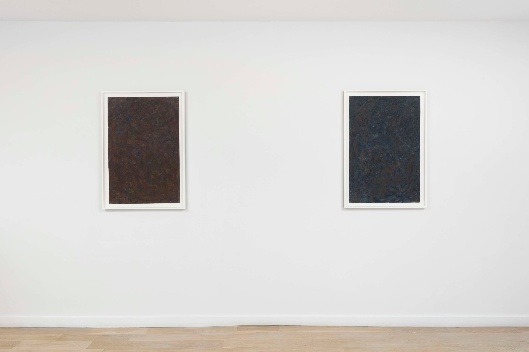 installation view of paintings in a white room
