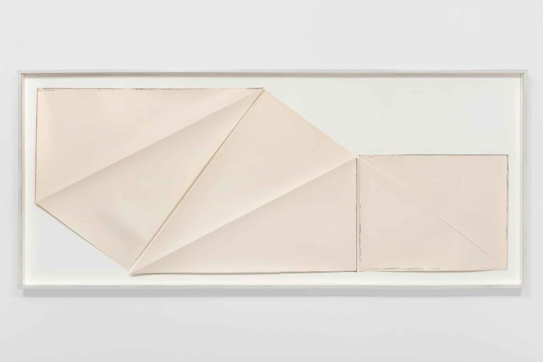 multiple pieces of paper that have been folded and cut put into a frame on a white boad