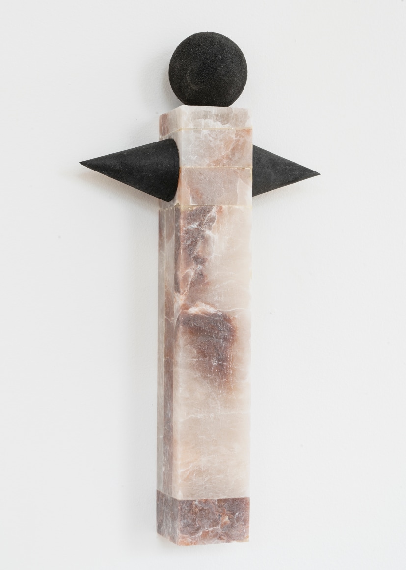 pink alabaster stone with black cones on the side and a black ball on top