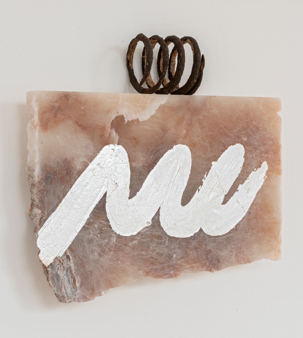 pink alabaster stone with swish of silver paint and rusted coil on top