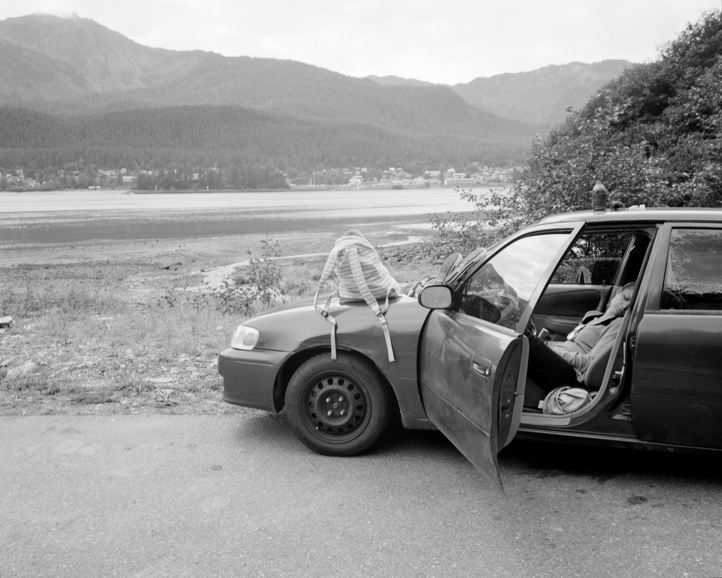 Patrice Aphrodite Helmar  Woman napping in her car - Thane Road, Alaska, 2017  C-print  41 x 51 cm / 16 x 20 in  Edition of 5 + 2 AP