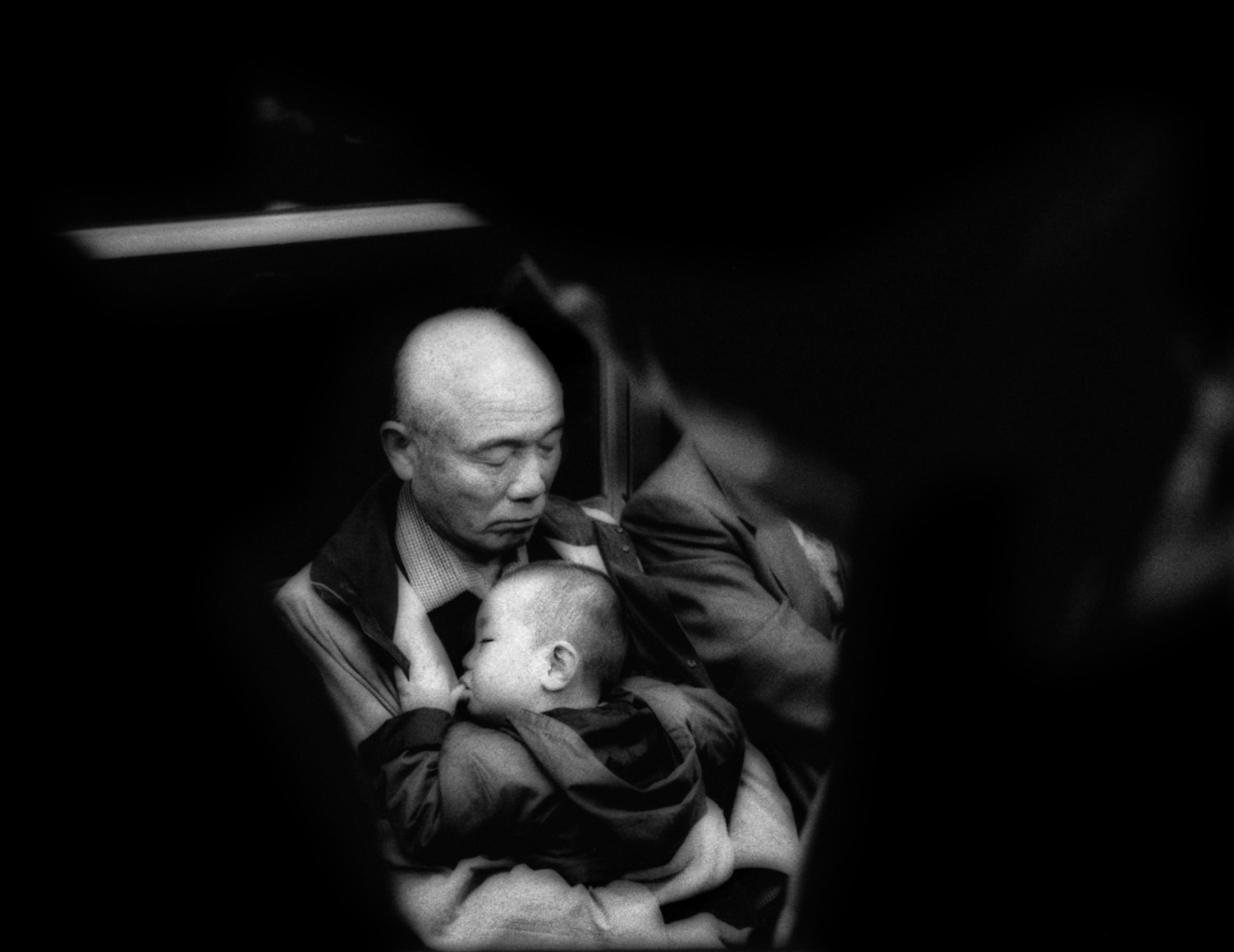 Sleeping man cradles sleeping child on subway, Tokyo, Japan, 2004 - Mangaland | James Whitlow Delano Documentary Photography