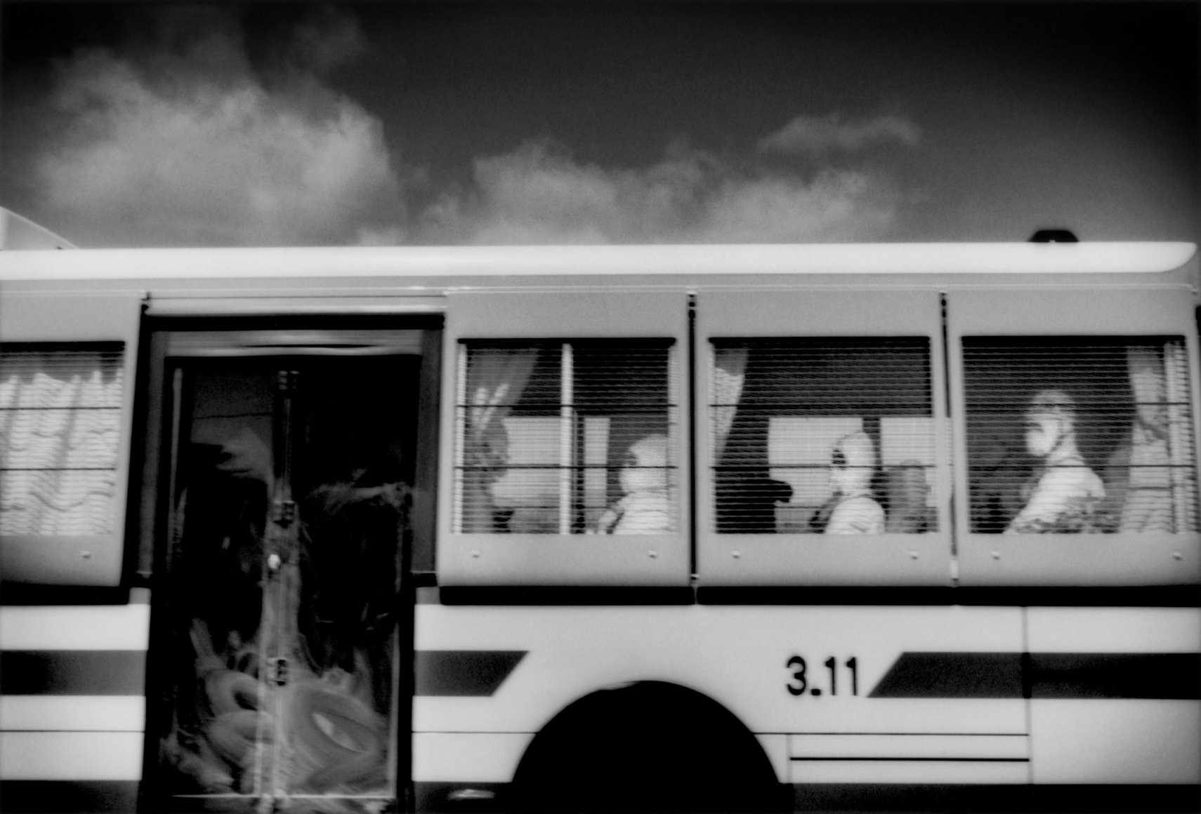 Recovery workers, probably police, wearing hazmat suits to protect them from radiation, enter 20 km no-entry zone via bus, Route 6, Minamisōma, Fukushima Prefecture, Japan, 2011