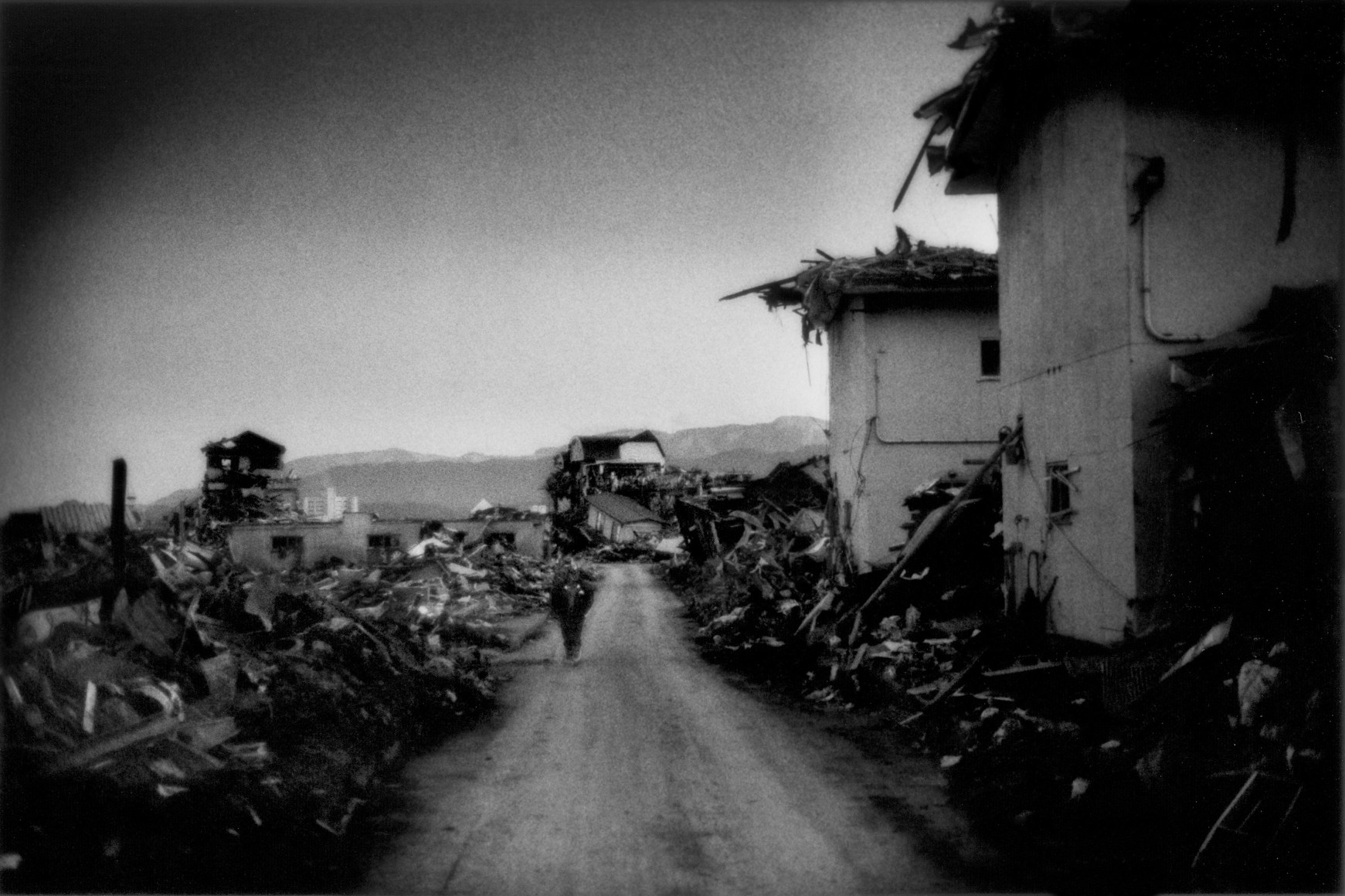 An elderly woman shuffles through a city wiped off the face of the earth by the Japan Tsunami, Rikuzen-Takata, Iwate Prefecture, Japan, 2011