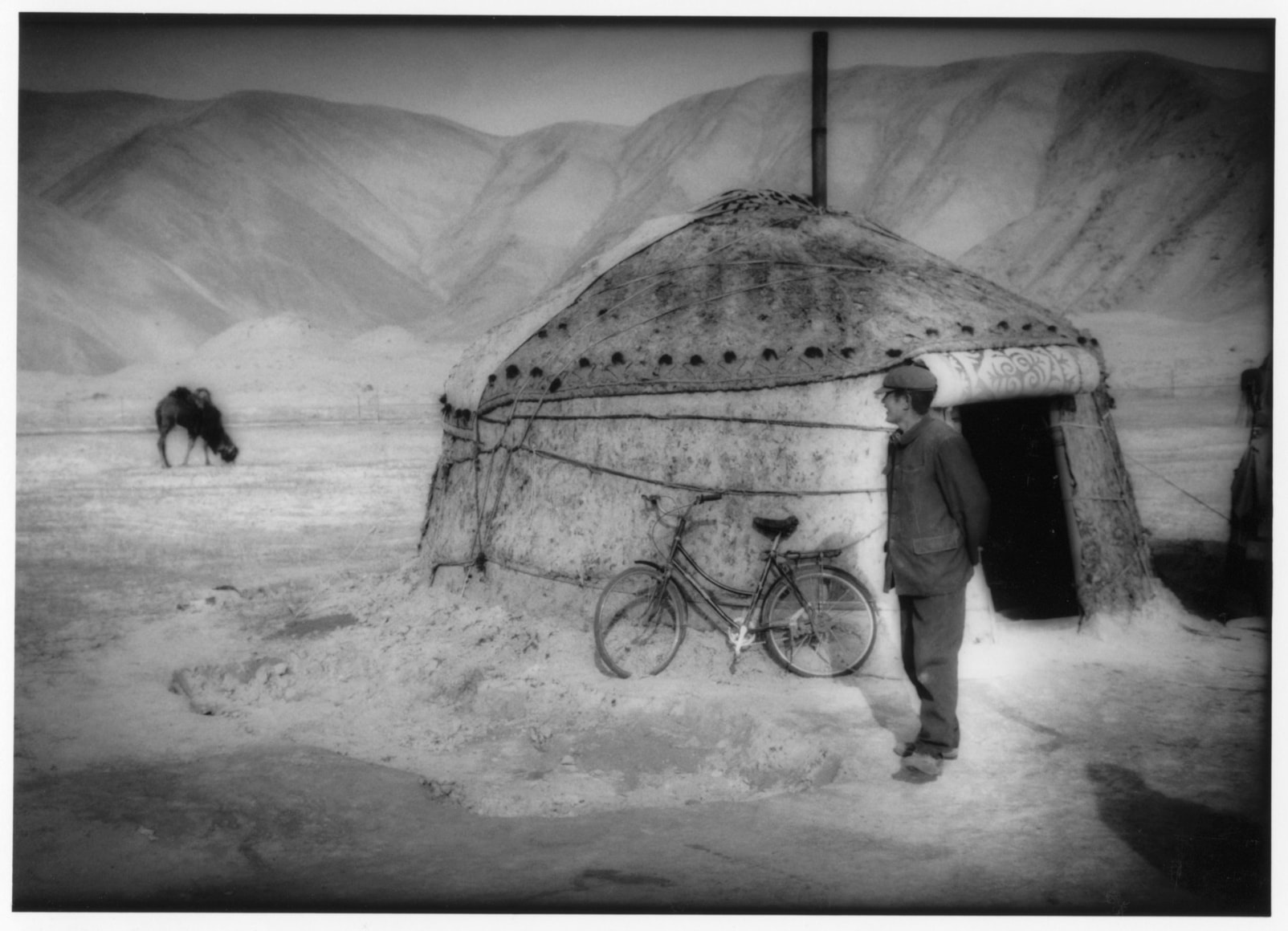 Kyrgyz herdsman watched his camels from outside his yurt - Empire | James Whitlow Delano Documentary Fine Art