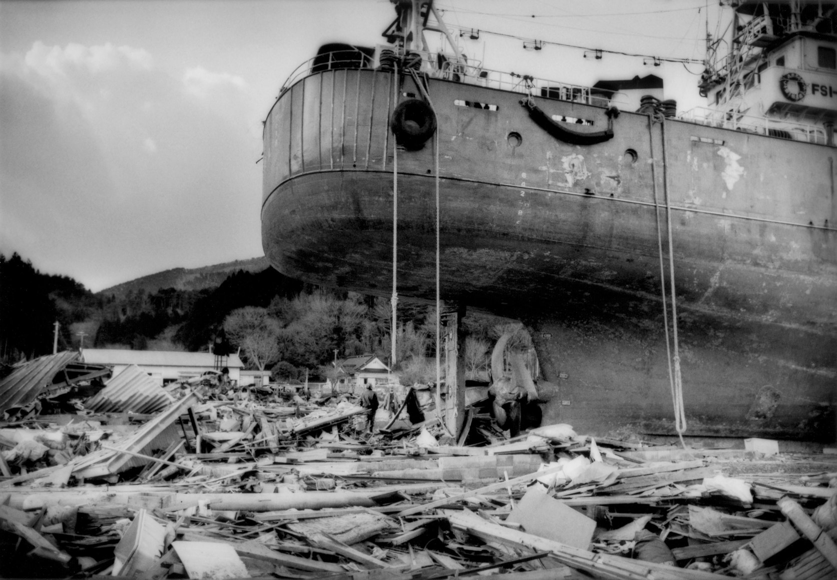 An ocean going ship sits where it came to rest in the debris of the great Tsunami that hit, Kesennuma, Miyagi Prefecture, Japan, 2011