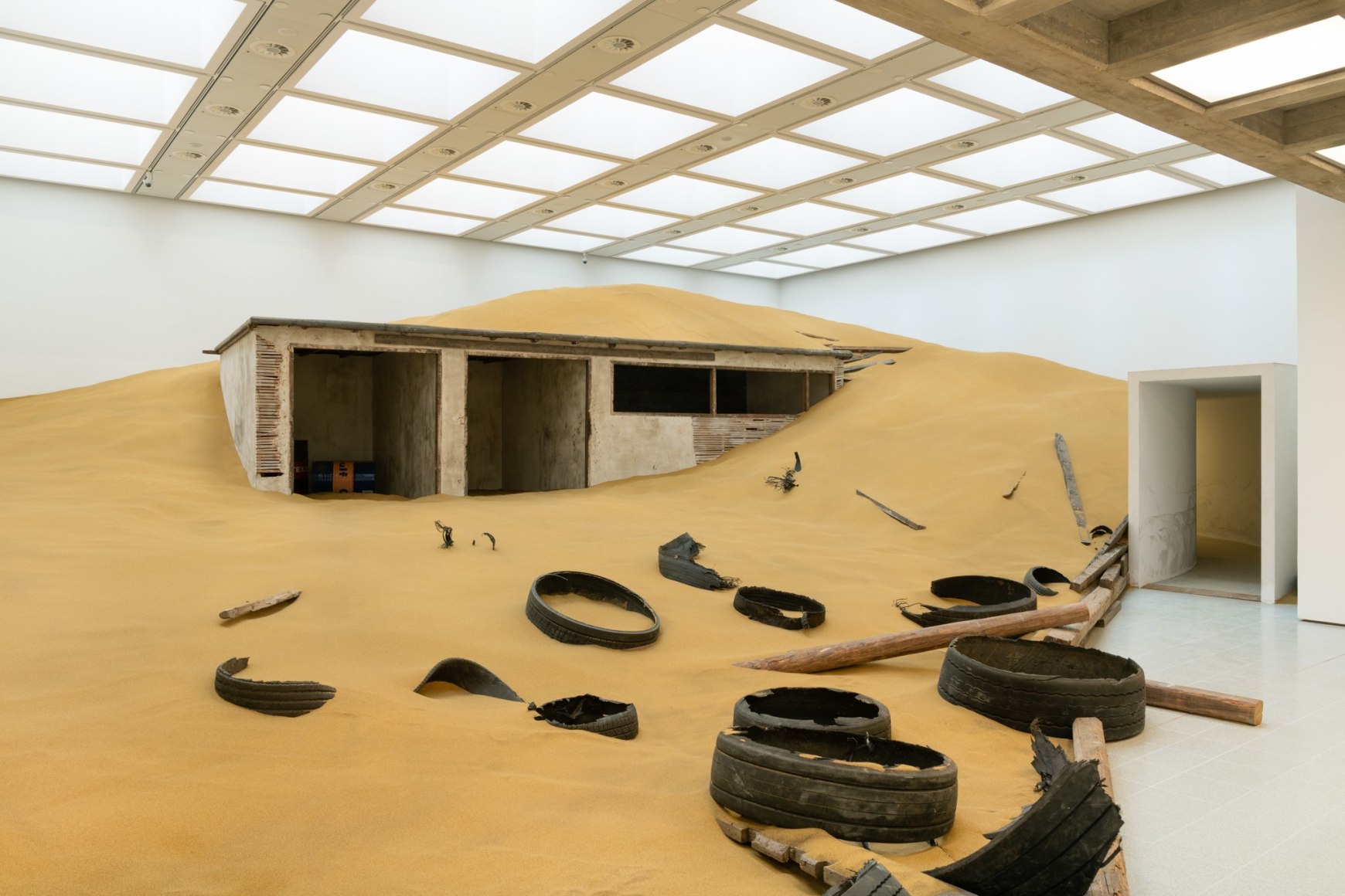 Installation view of Mike Nelson, Triple Bluff Canyon (the woodshed), 2004. Various materials. M25, 2023., Found tyres. Photo: Matt Greenwood. Courtesy the artist and the Hayward Gallery.