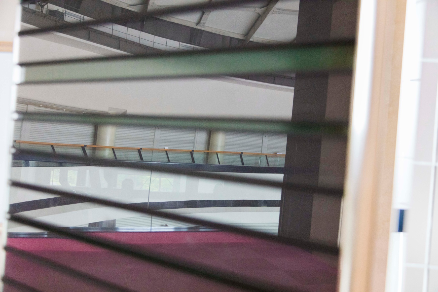 Color photo a building interior with out of focus horizontal architectural elements in the foreground.