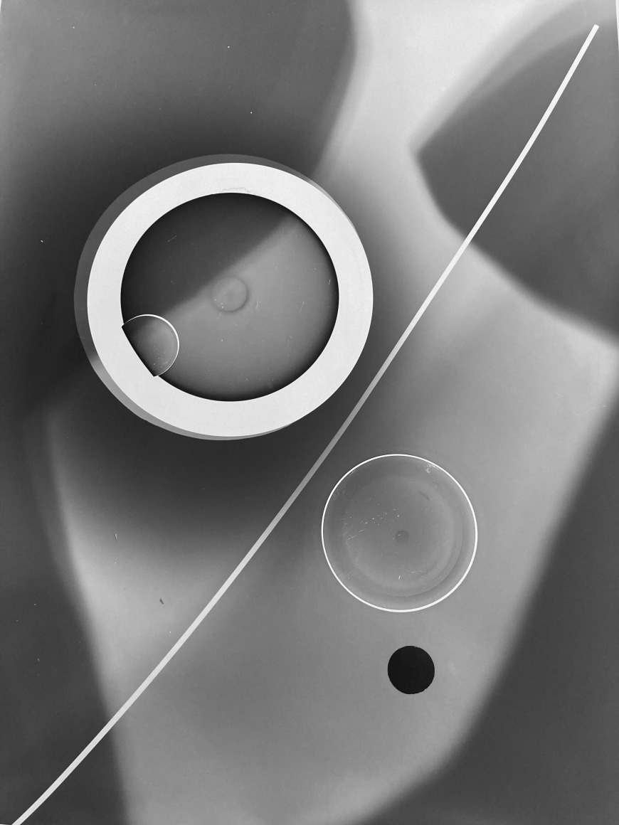 Black and white abstract photo print showing abstract composition made of brighter concentric circles and darker lines.