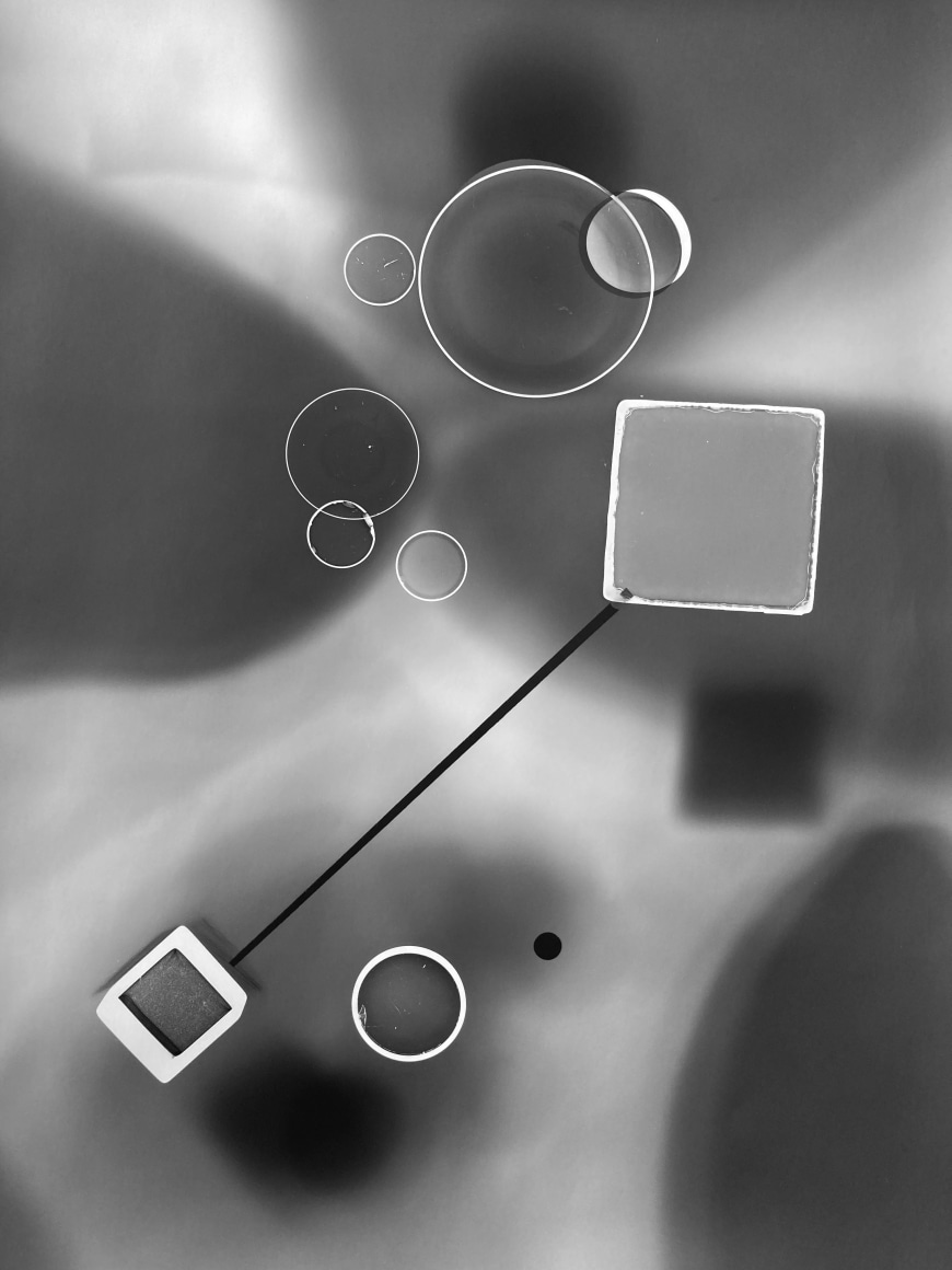 Black and white abstract photo print showing abstract composition made of brighter concentric circles and squares and darker lines.