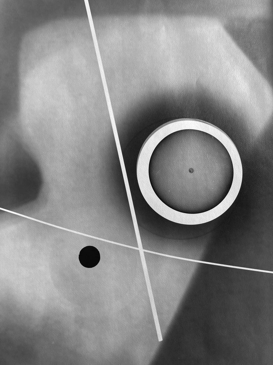 Black and white abstract photo print showing abstract composition made of brighter concentric circles and darker lines.