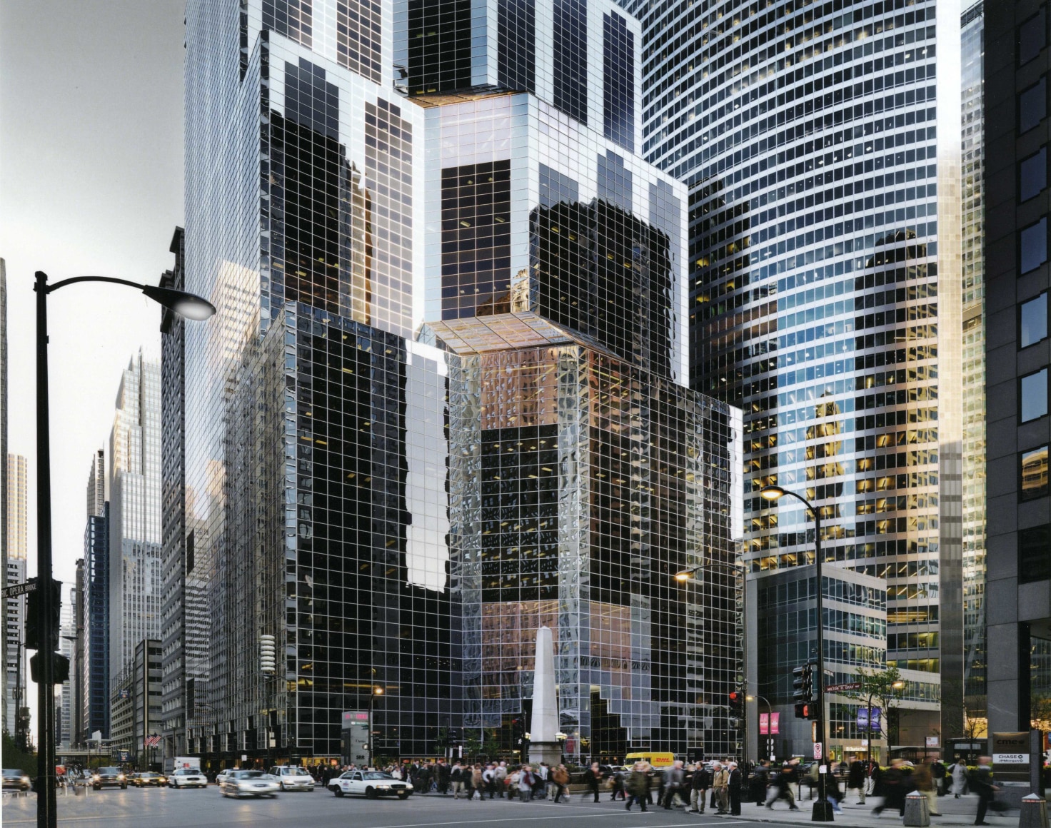 Color photo of a busy Chicago street with glass skyscrapers filling the frame in the middle ground