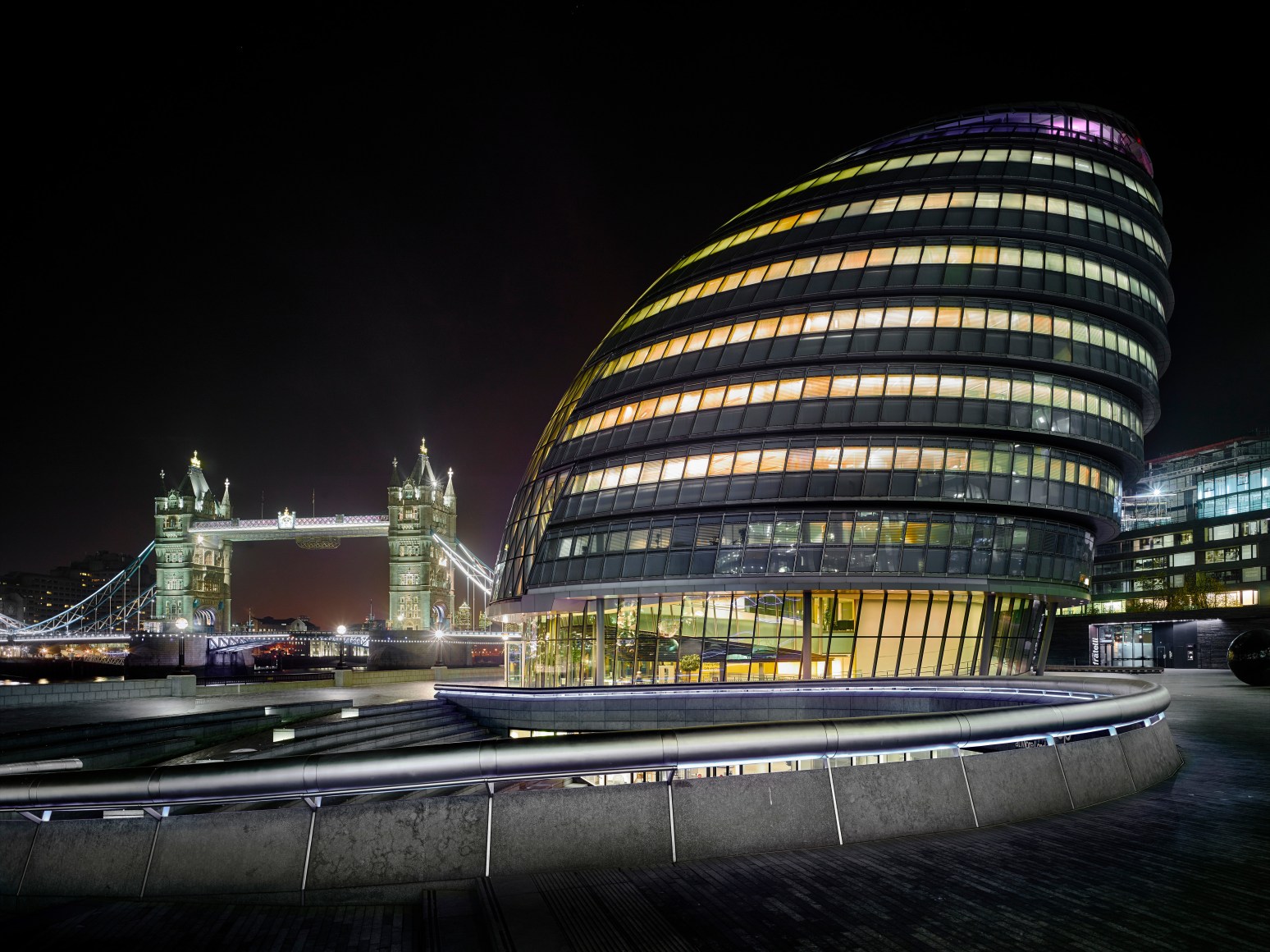 Photo of London, London bridge in background, a curvilinear example of contemporary architecture in the foreground