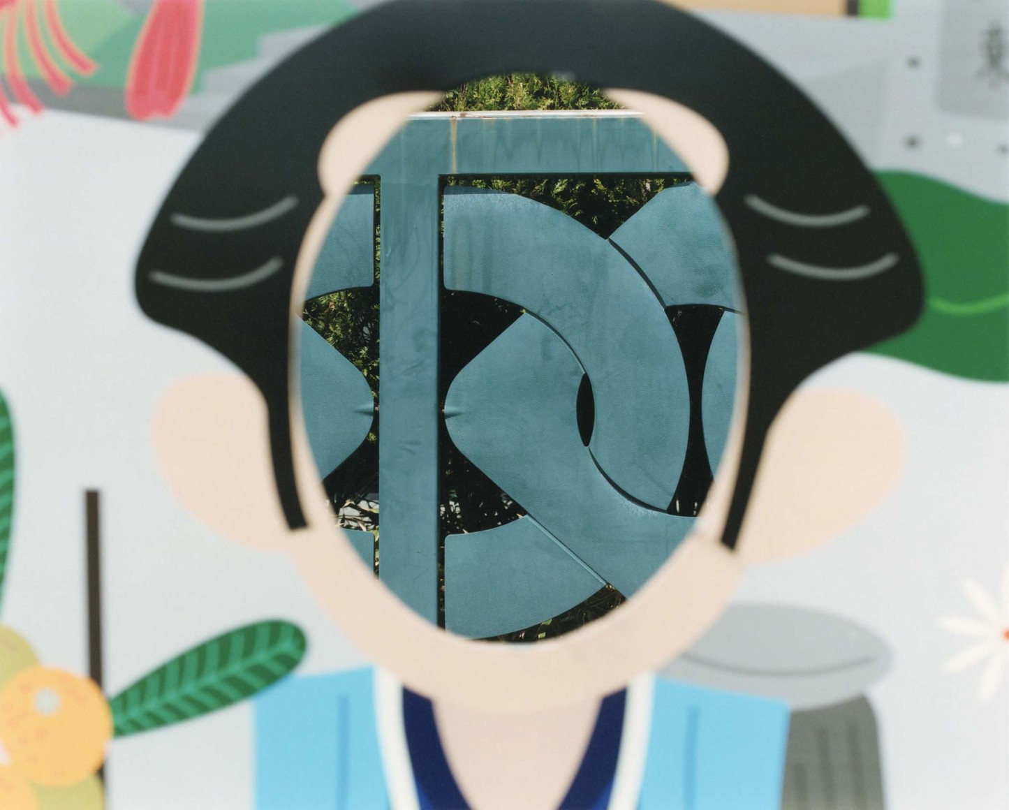 Color photograph of a Japanese photo-op&mdash;an out of focus cut-out face for tourists is shown as a window through which the landscape in the background is framed.
