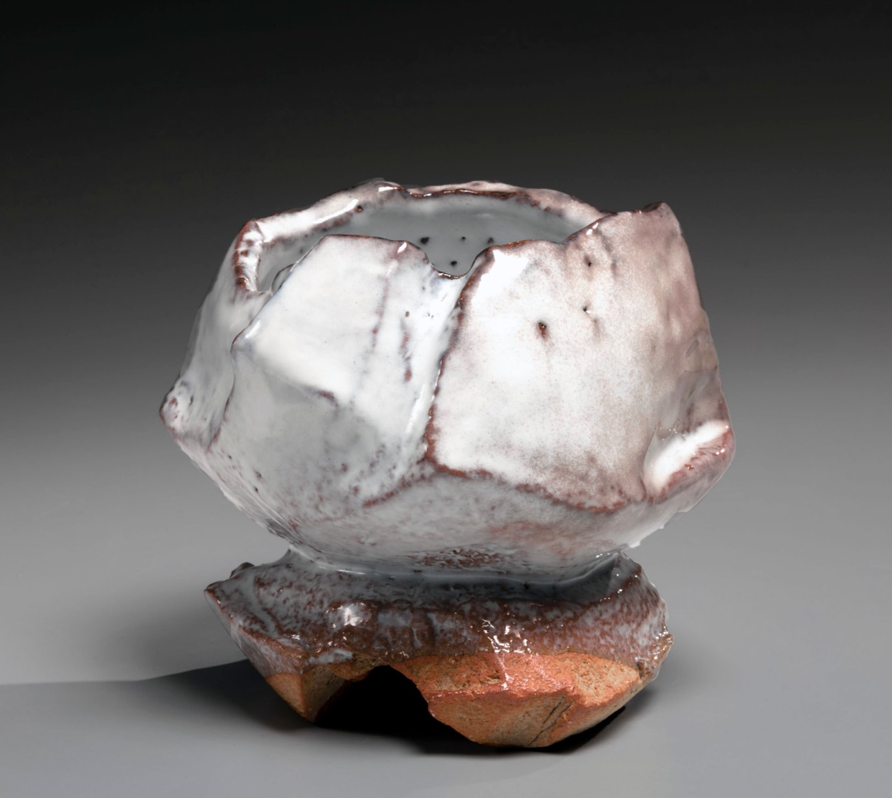 Kaneta Masanao (b. 1953), Round teabowl with irregular mouth, tall split foot, Hagi glaze and kiln effects