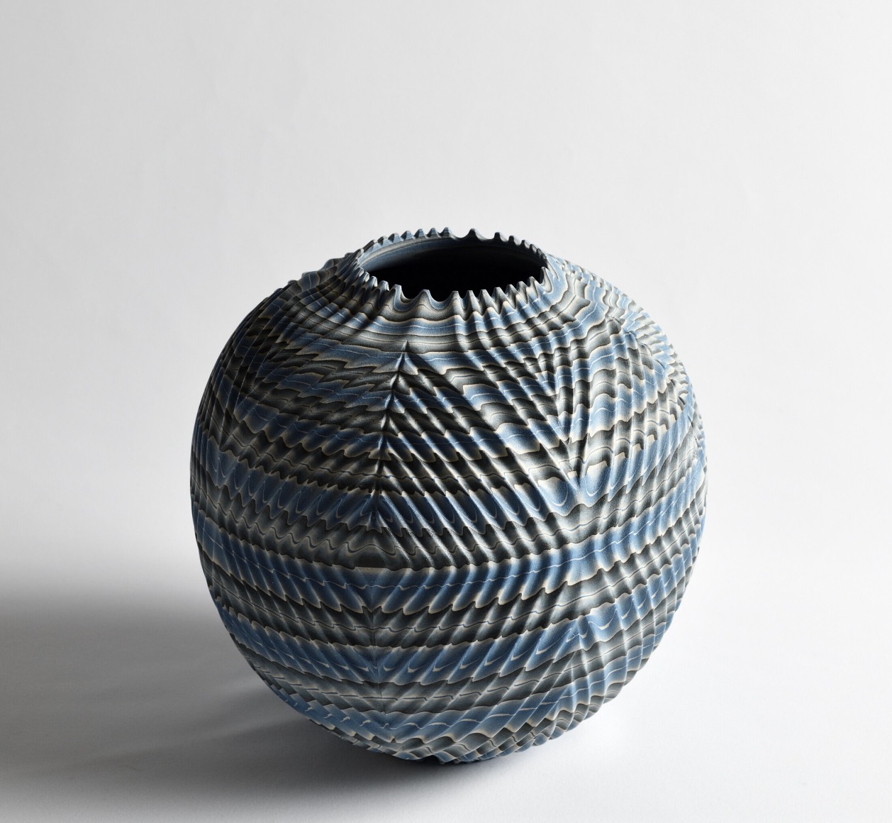 Ogata Kamio (b. 1949), Neriage&nbsp;(marbleized) vessel with carved, ridged surface, short spiked mouth and concentric triangular carving titled &ldquo;Waves&rdquo;