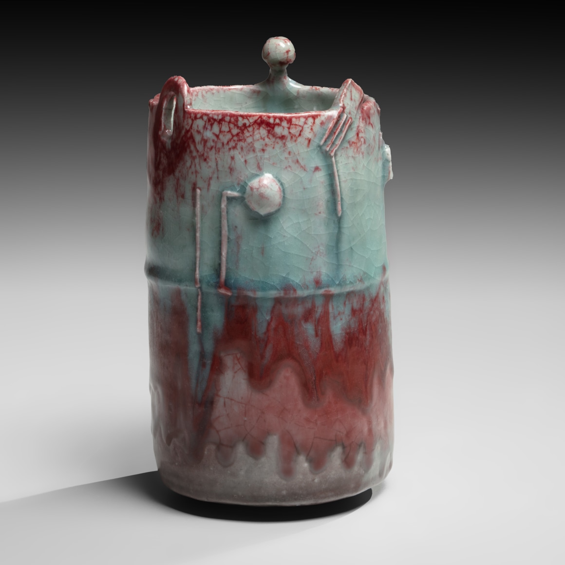 Vase with dripping glaze in blues and reds and abstract geometric designs in relief