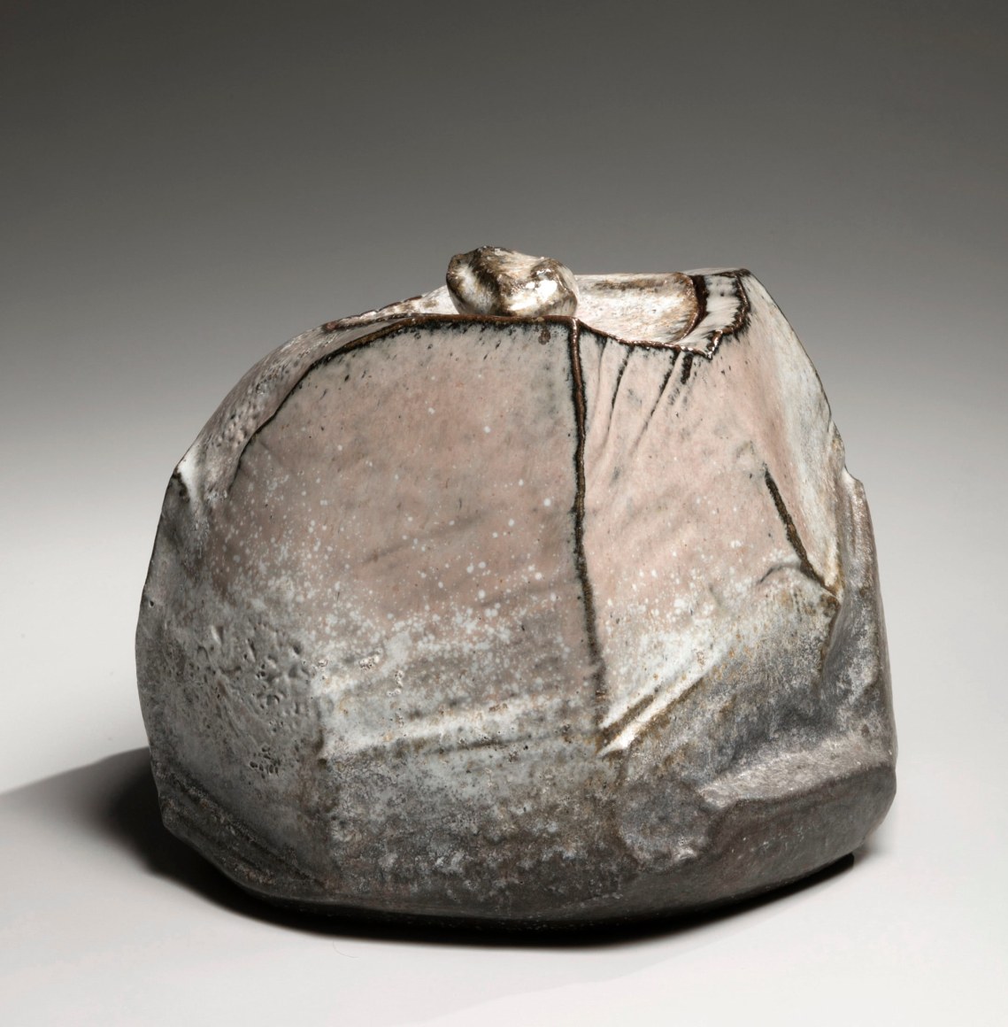 Kaneta Masanao (b. 1953), Covered water storage jar with multi-plane body, unctuous Hagi glaze, kiln effects&nbsp;and matching lid with knob handle