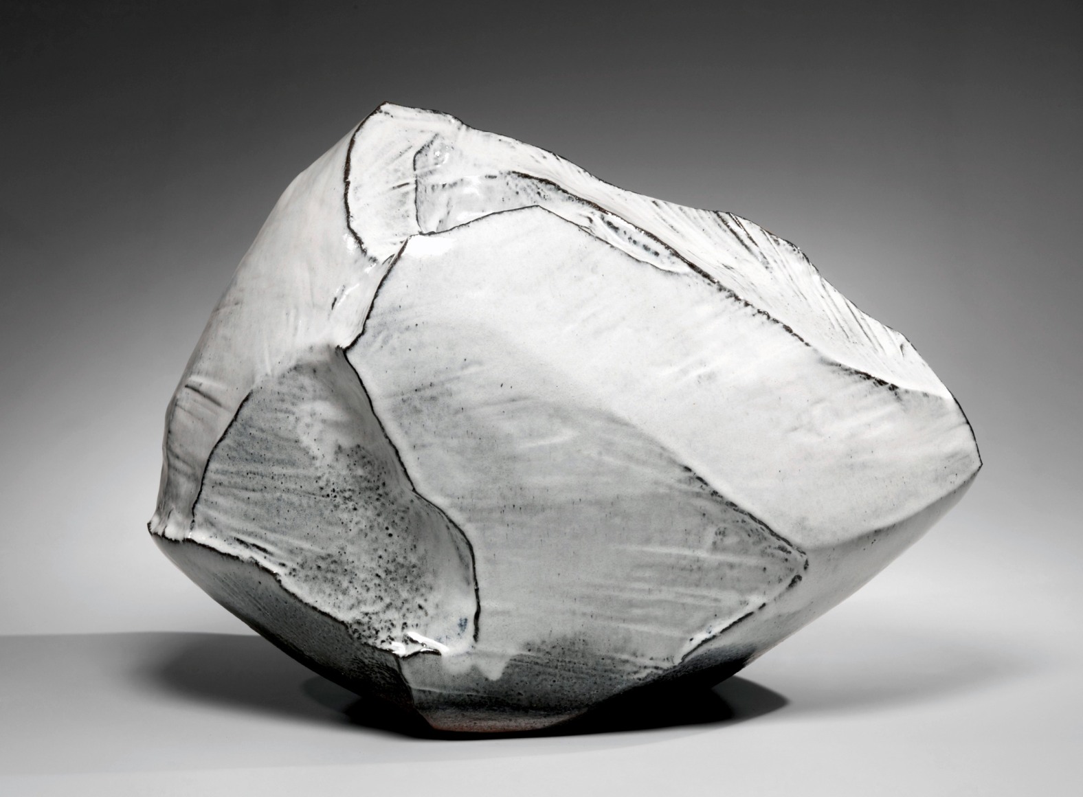 Kaneta Masanao (b. 1953), Rock-like, horizontal, scooped-out vessel with multi-planed body and unctuous Hagi glazes