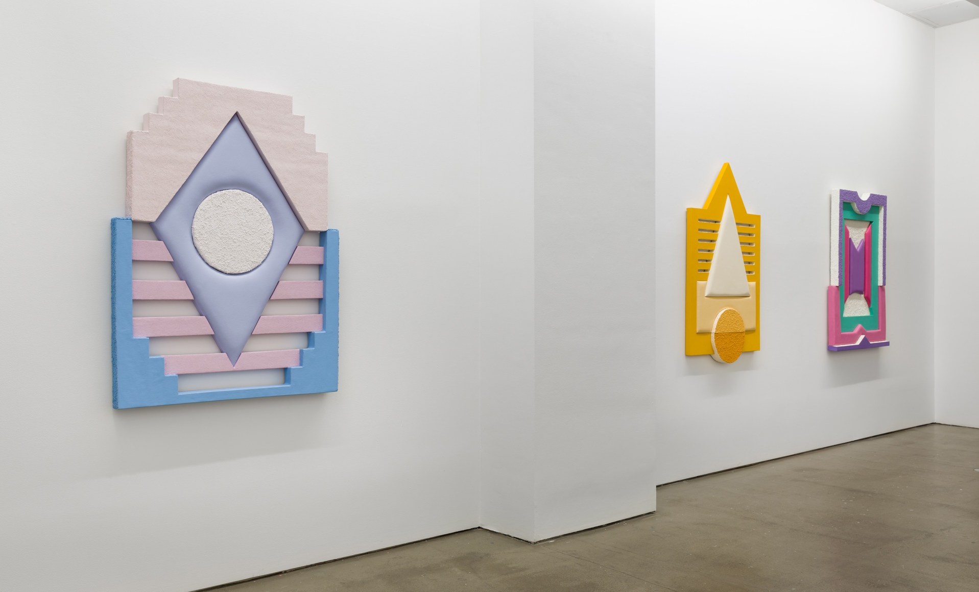 Installation views of Leah Guadagnoli's solo exhibition. Geometric sculptures made from fabric, foam, and pumice stone line the walls.