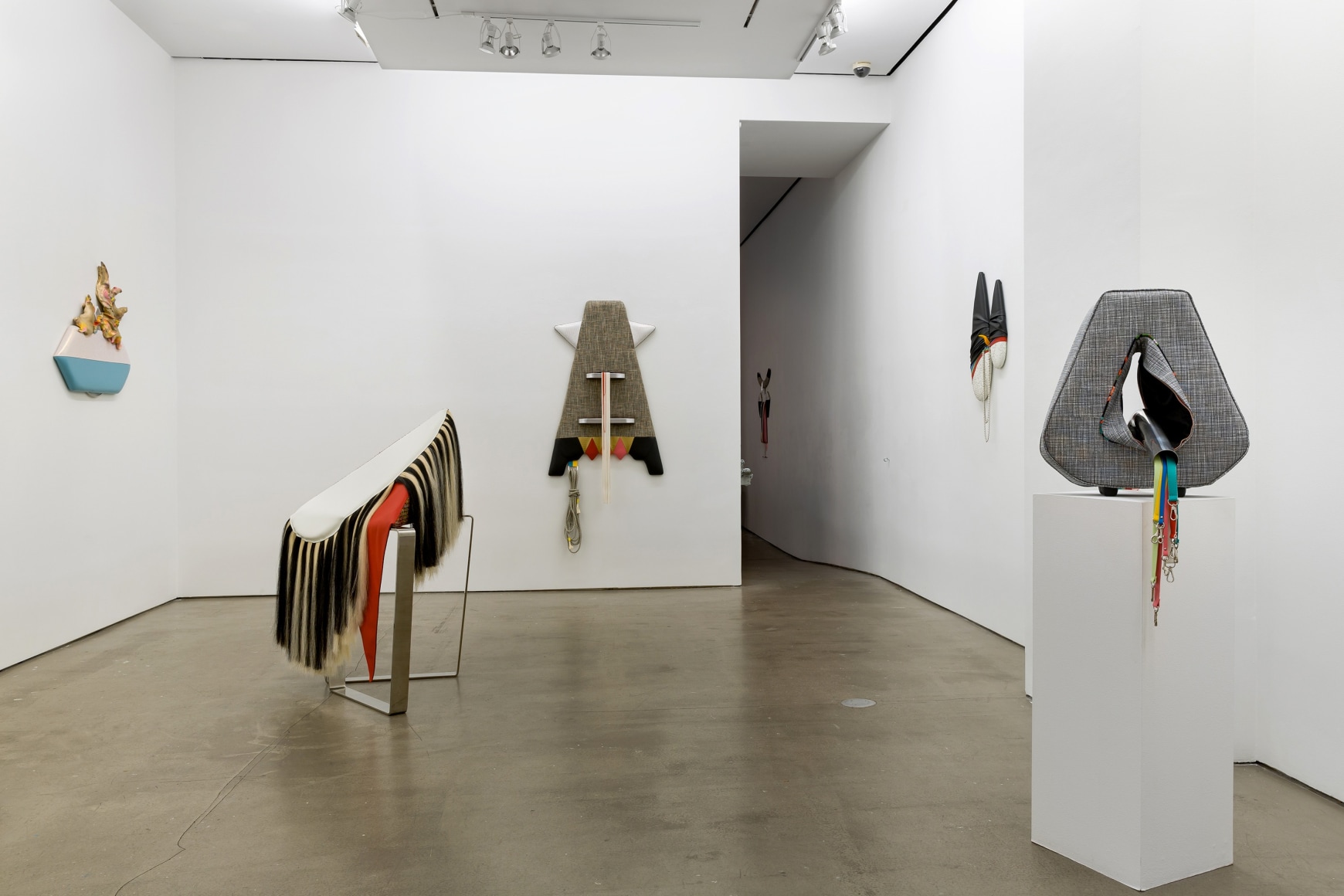 Installation view of Trish Tillman's exhibition "Stage Diver", which shows plush sculptures on the walls and standing on the floor.