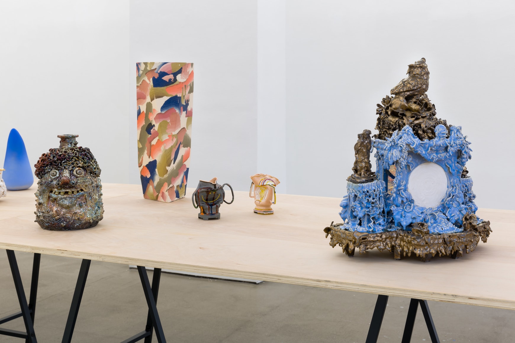 An installation view of the group exhibition &quot;Morph&quot;. There are many sculptures on a table in the gallery