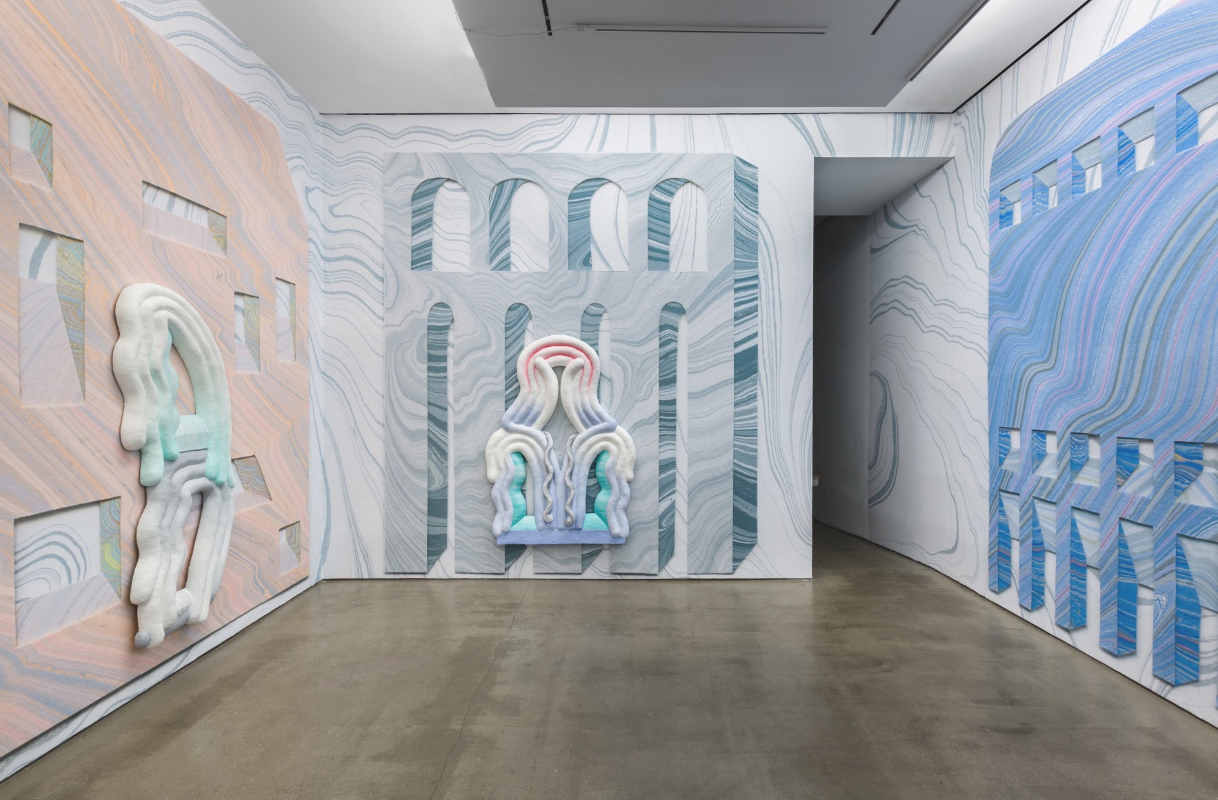 Installation view from Lauren Clay's solo exhibition. Large sculptural pieces hang on the wall. The wall is papered with custom-made wallpaper.