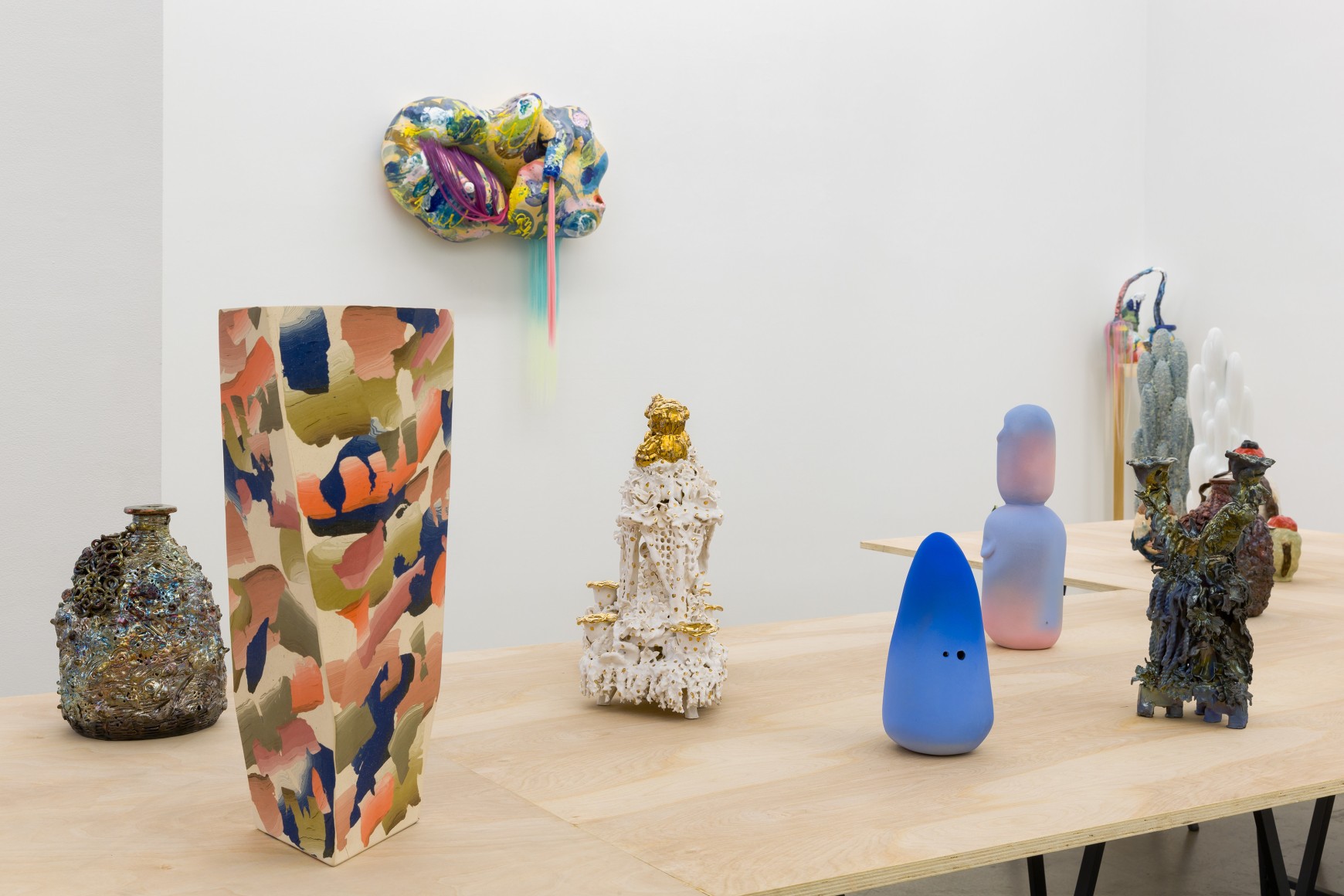 An installation view of the group exhibition &quot;Morph&quot;. There are many sculptures on a table in the gallery