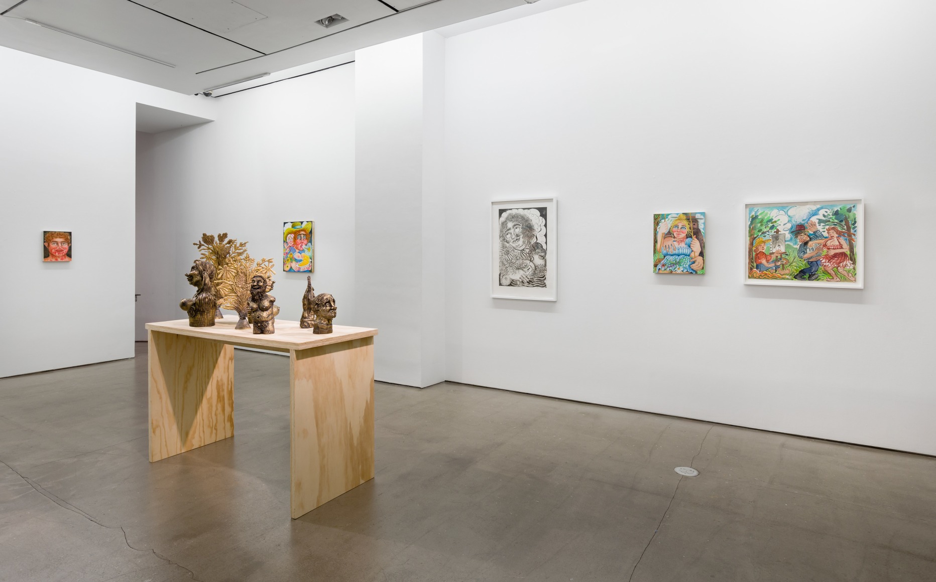 Installation view of "Town and Country" by Rebecca Morgan. Sculptures on a table and paintings and prints on the wall