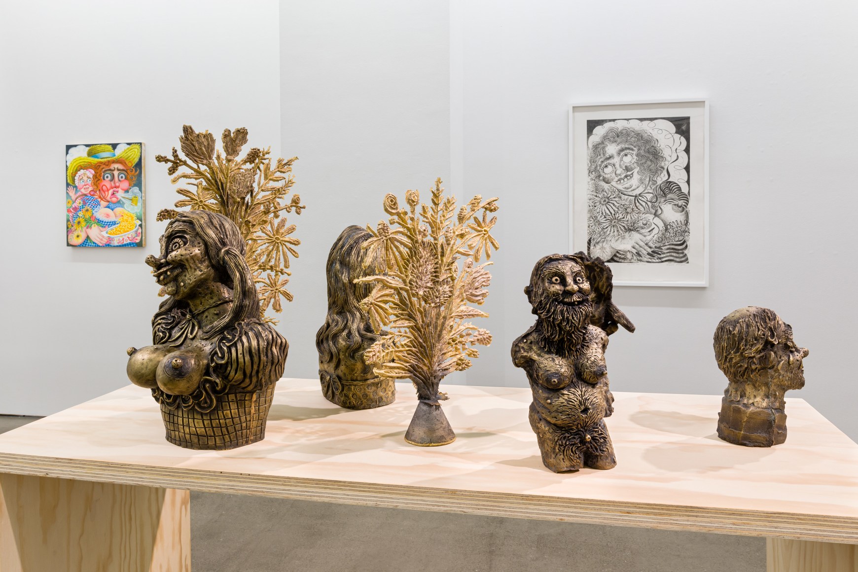 Installation view of "Town and Country" by Rebecca Morgan. Sculptures on a table and paintings and prints on the wall