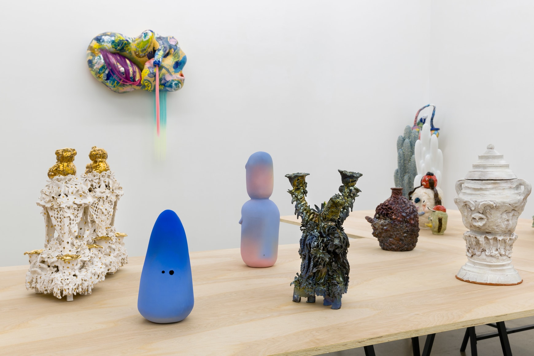 An installation view of the group exhibition &quot;Morph&quot;. There are many sculptures on a table in the gallery