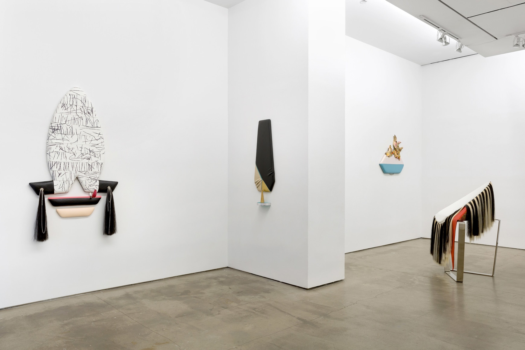 Installation view of Trish Tillman's exhibition "Stage Diver", which shows plush sculptures on the walls and standing on the floor.