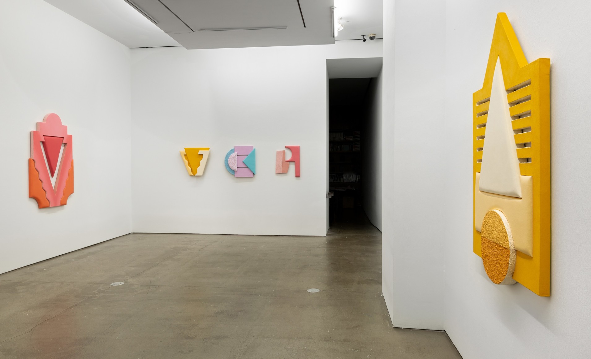 Installation views of Leah Guadagnoli's solo exhibition. Geometric sculptures made from fabric, foam, and pumice stone line the walls.