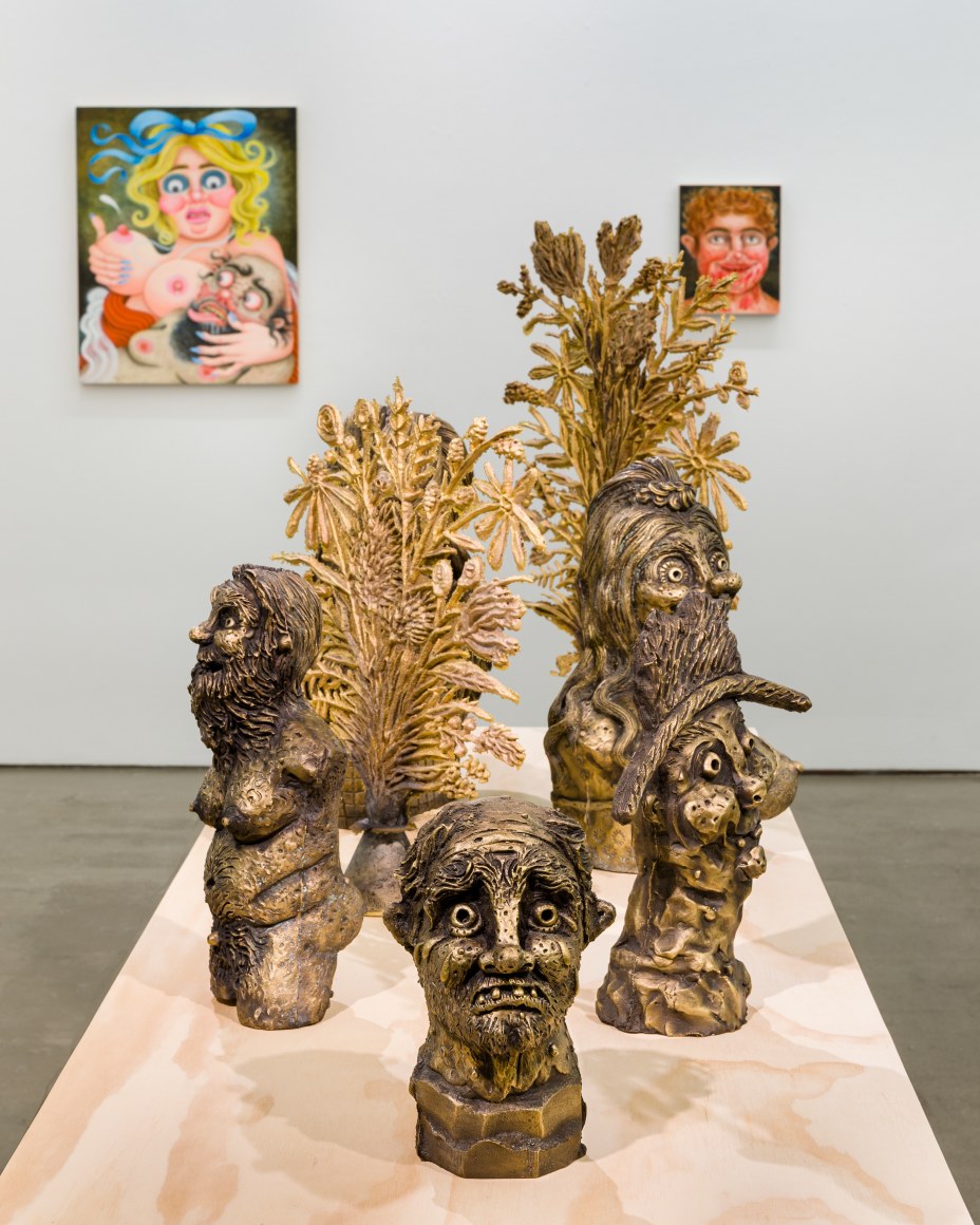 Installation view of "Town and Country" by Rebecca Morgan. Sculptures on a table and paintings and prints on the wall