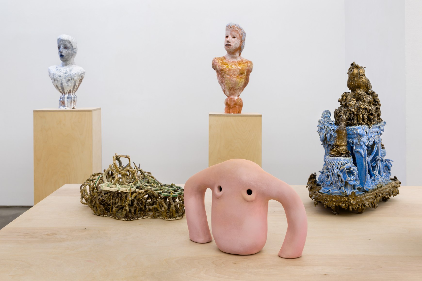 An installation view of the group exhibition &quot;Morph&quot;. There are many sculptures on a table in the gallery
