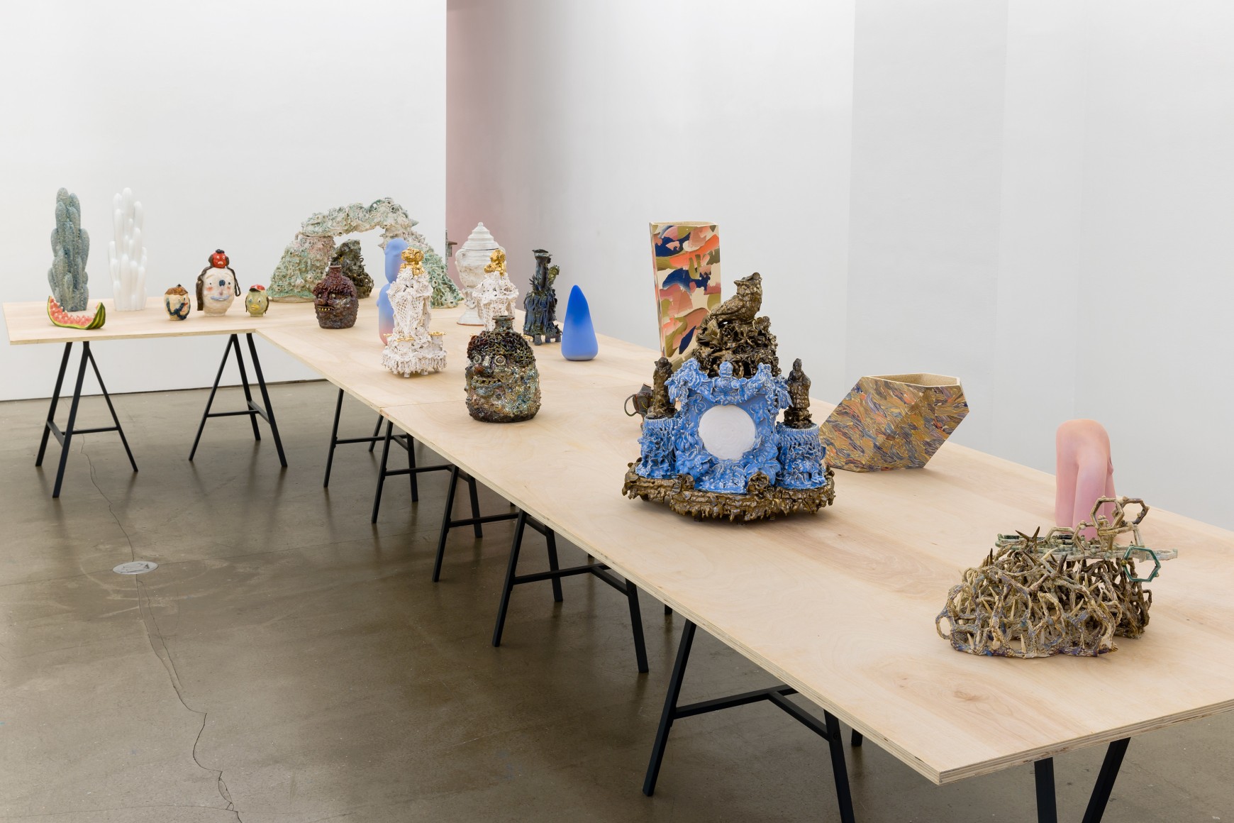 An installation view of the group exhibition &quot;Morph&quot;. There are many sculptures on a table in the gallery
