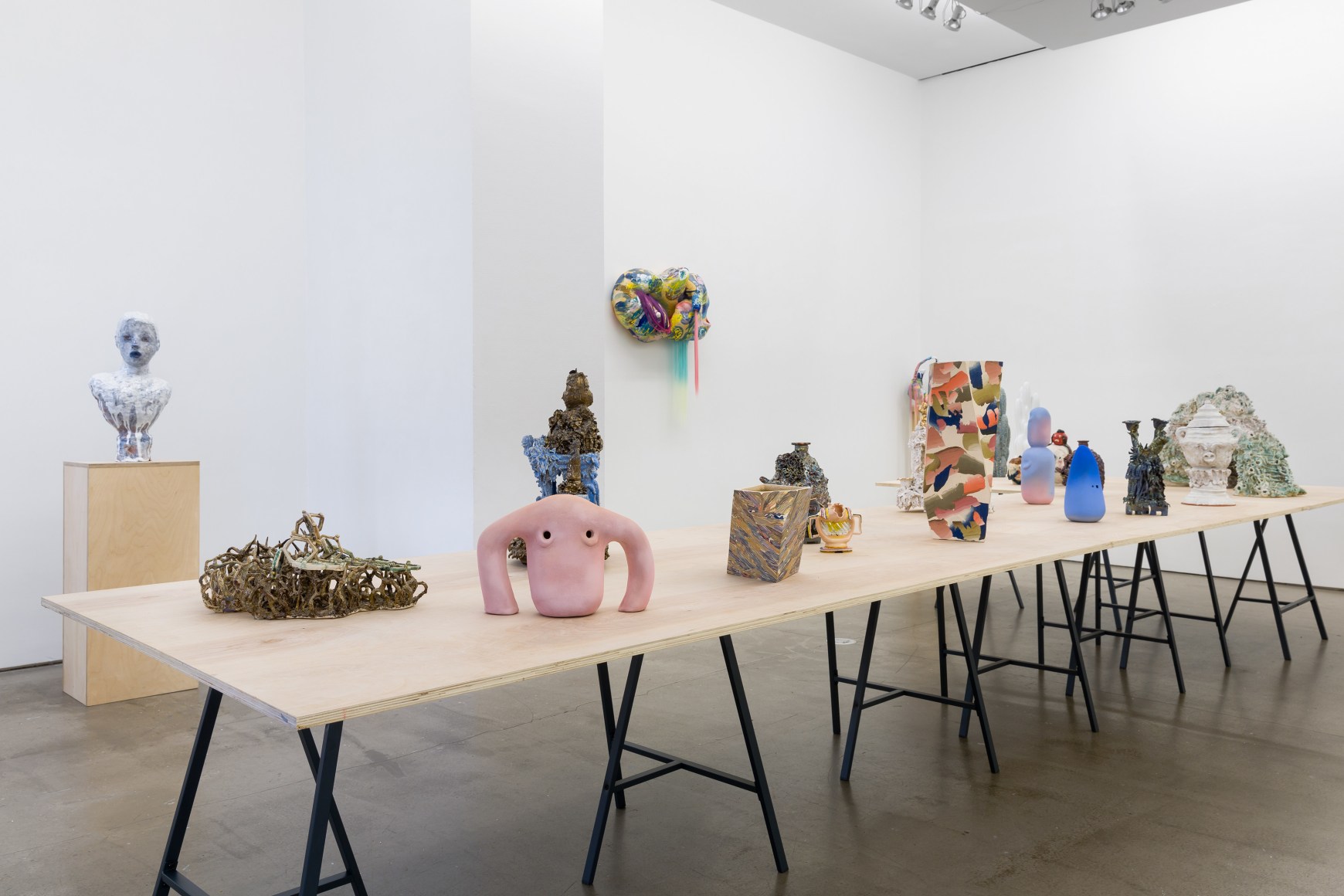 An installation view of the group exhibition &quot;Morph&quot;. There are many sculptures on a table in the gallery