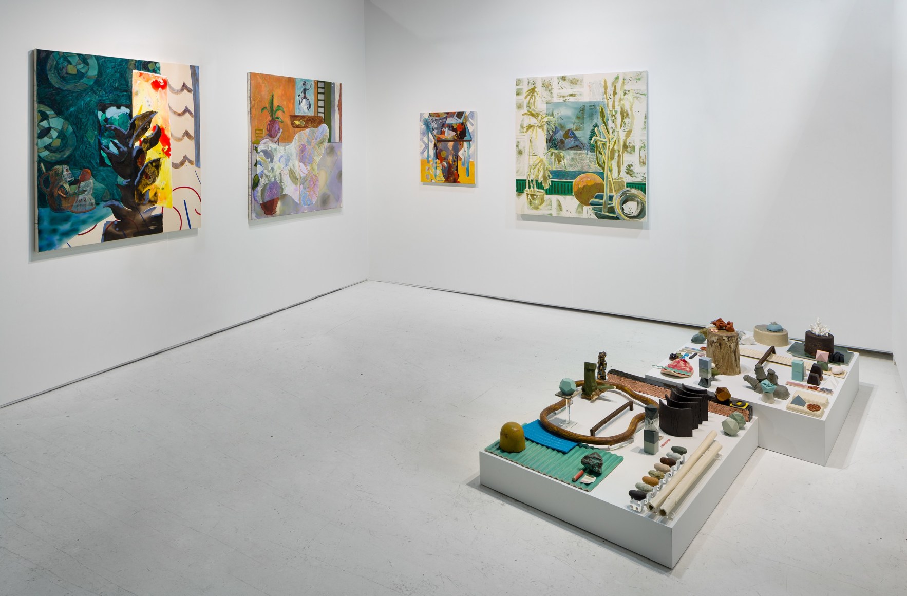 Installation of an open art fair booth, showcasing artwork on the walls. A large ceramic installation is on the floor.