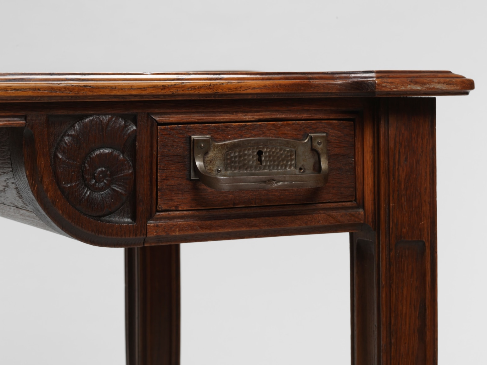 photograph in blank room of desk by Gauthier made in wood with detailing throughout, four legs and drawers.
