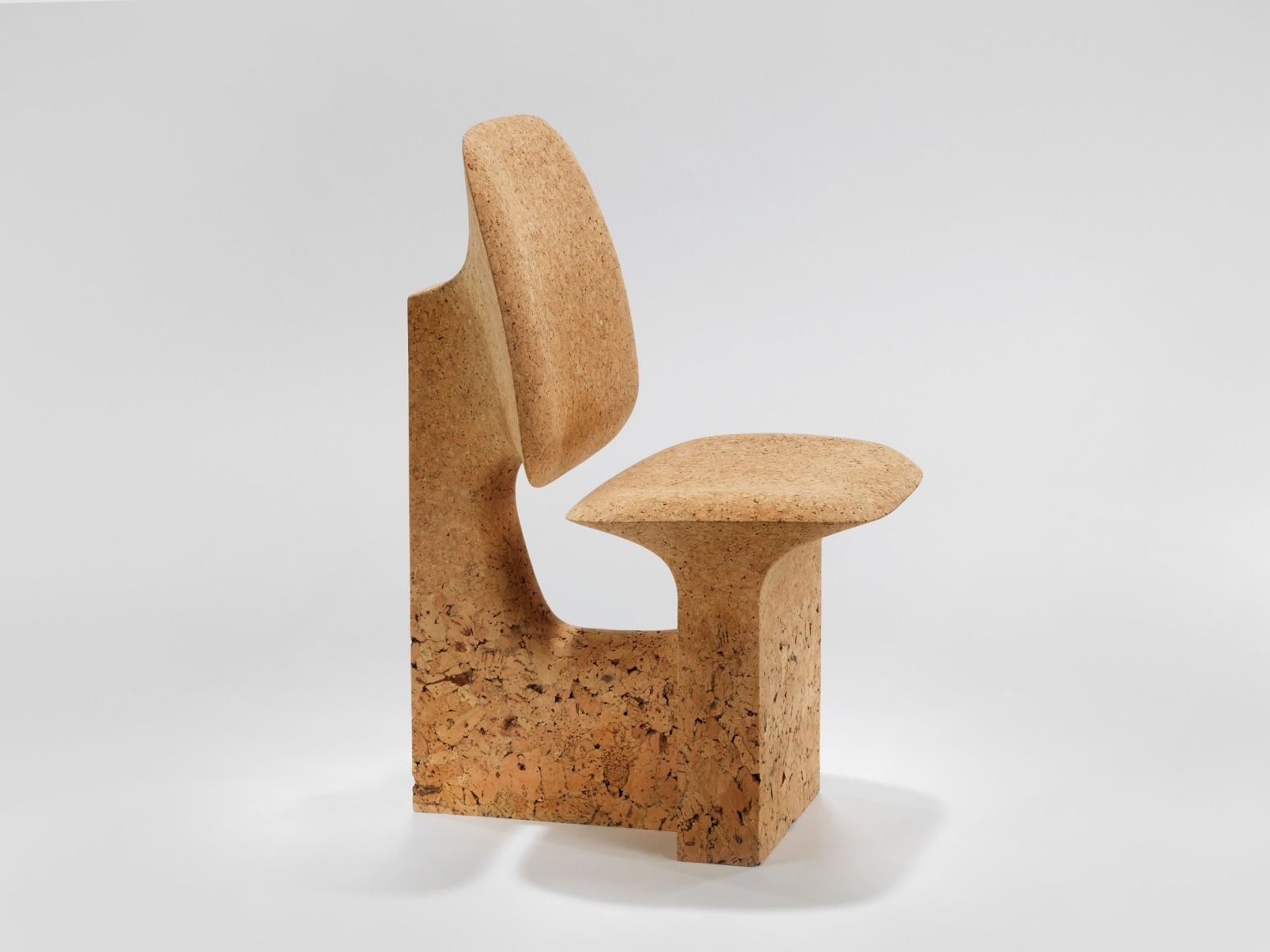 cork chair with great curves by made in situ. Image with grey background.