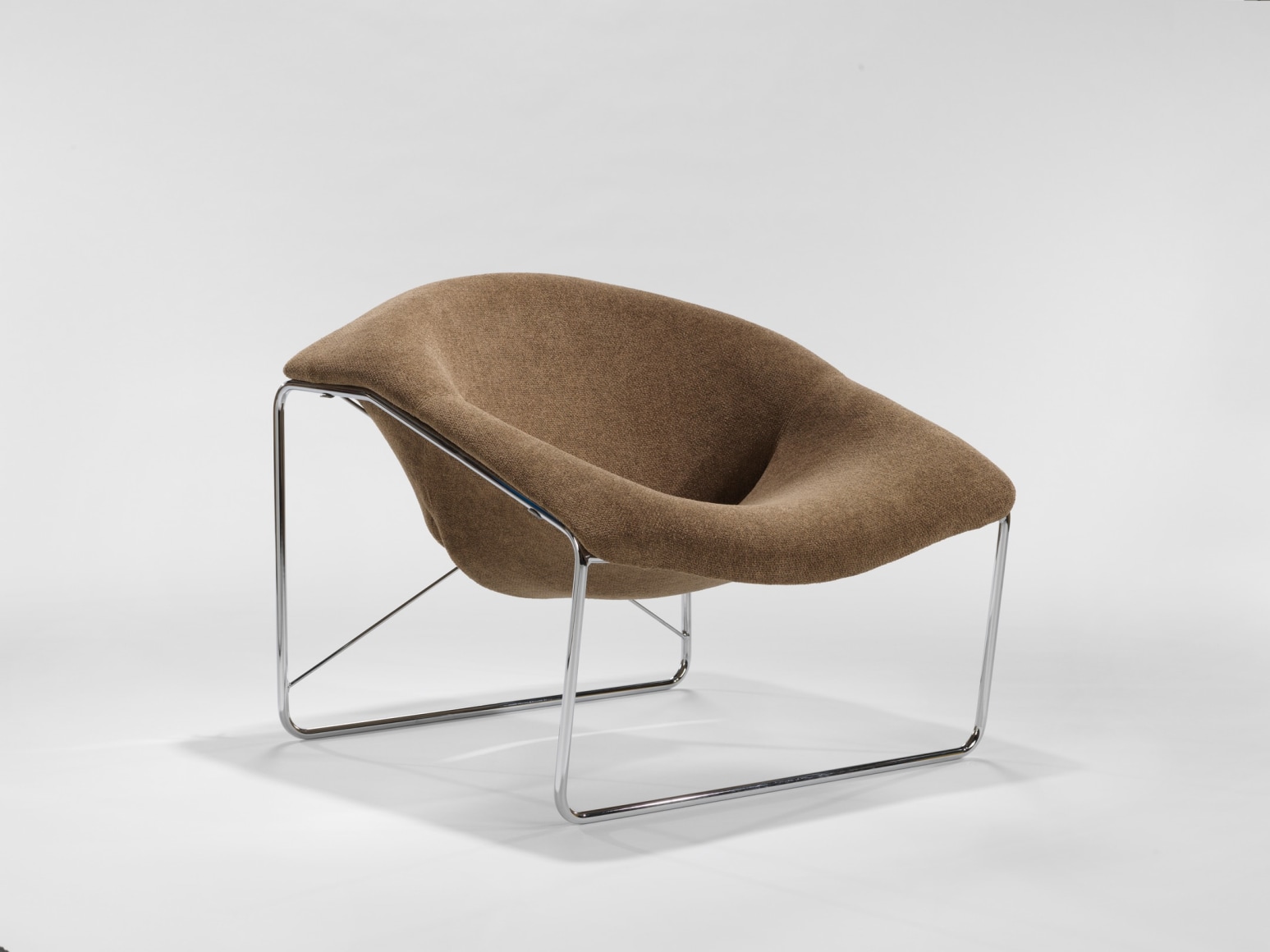 photograph of chair in a blank room with metal legs