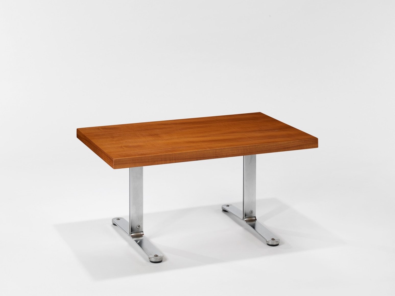 photograph in blank room with table by Tallon made with teak wood top and steel and metal legs